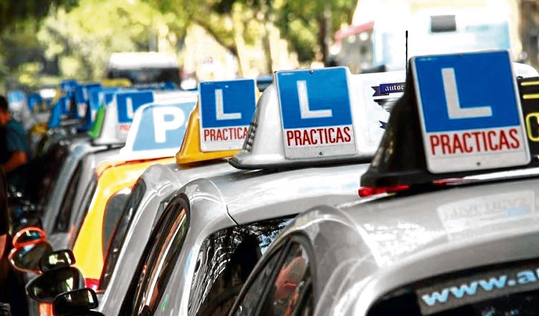 Varios coches de autoescuelas aparcados antes de un examen práctico