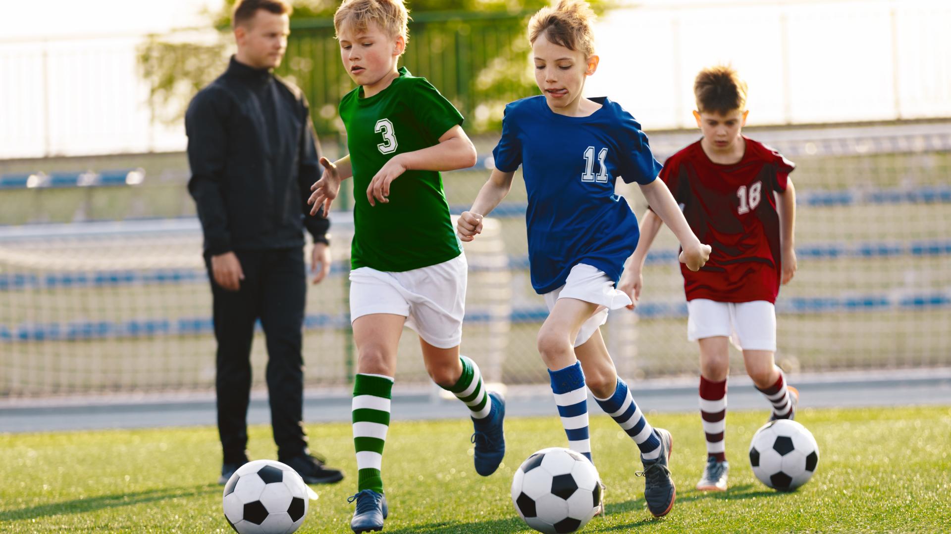Niños entrenando a fútbol.