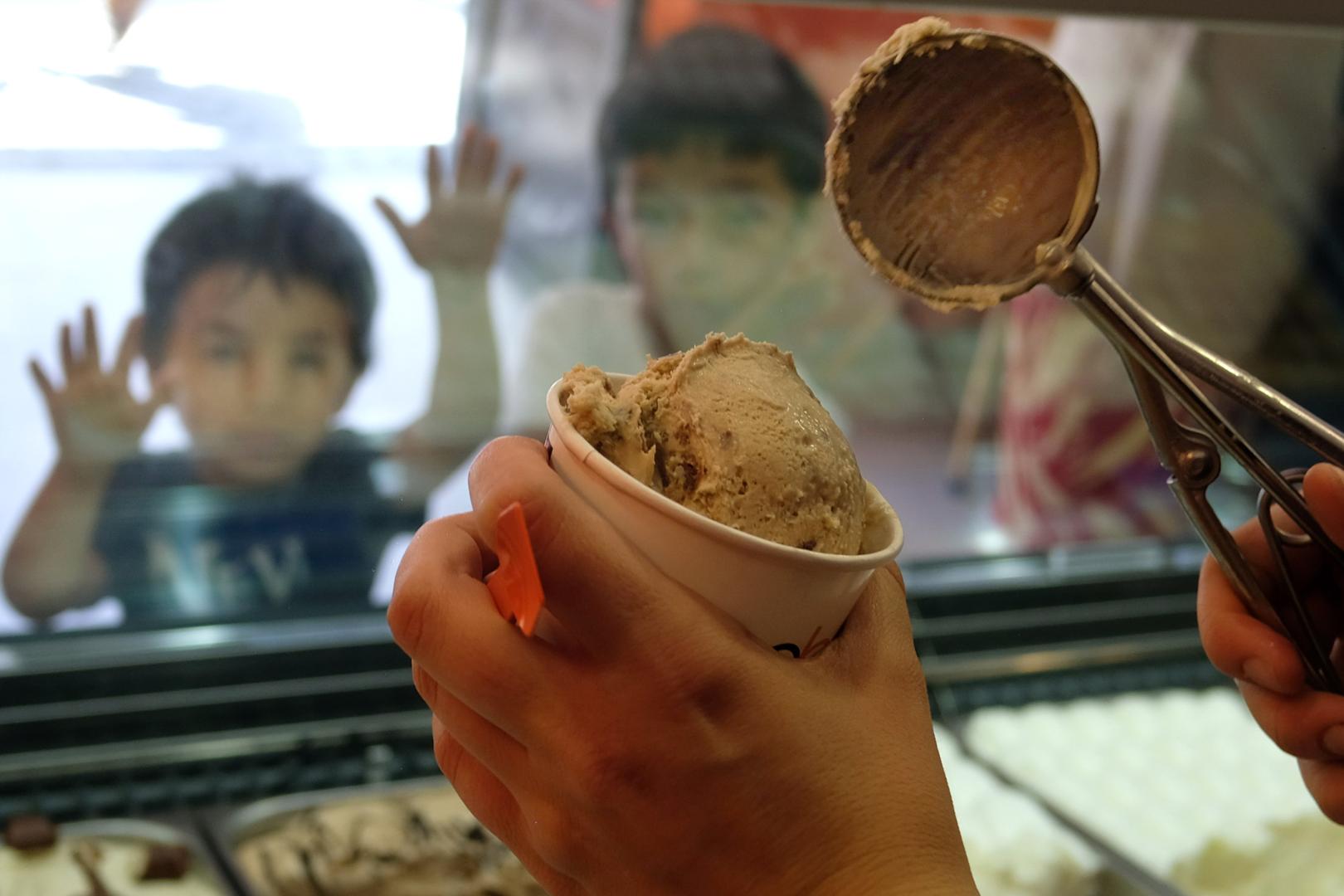 Unos niños esperan con ganas que les sirvan su helado