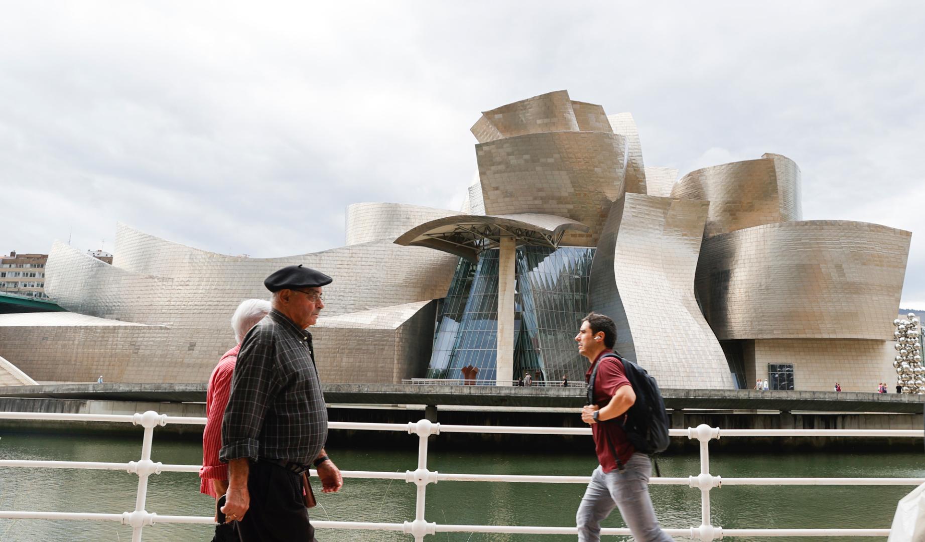Varias personas pasan ante el Museo Guggenheim de Bilbao, obra del arquitecto Frank Gehry, que este año conmemora su 25 aniversario