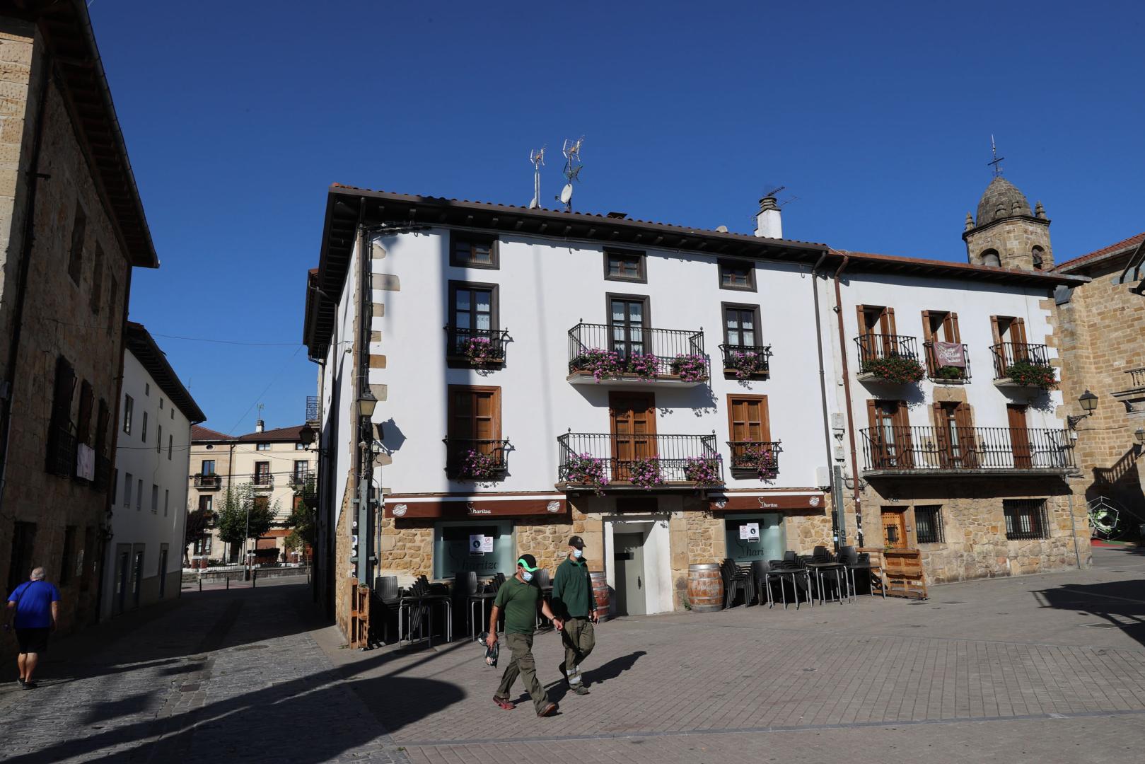 Dos operarios municipales cruzan por la plaza de los Fueros, de Alsasua
