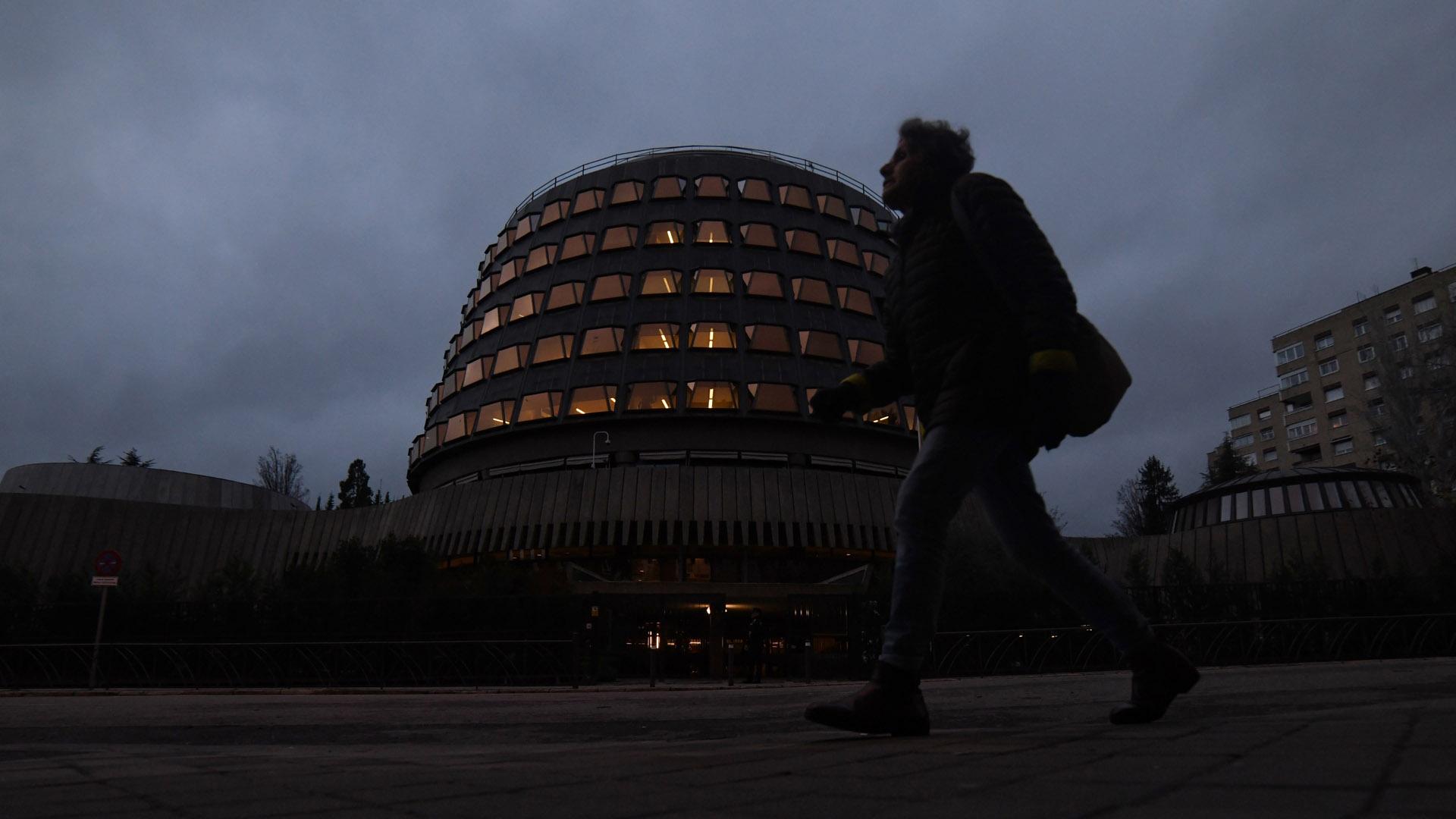 Una persona camina junto al edificio del Tribunal Constitucional, en Madrid