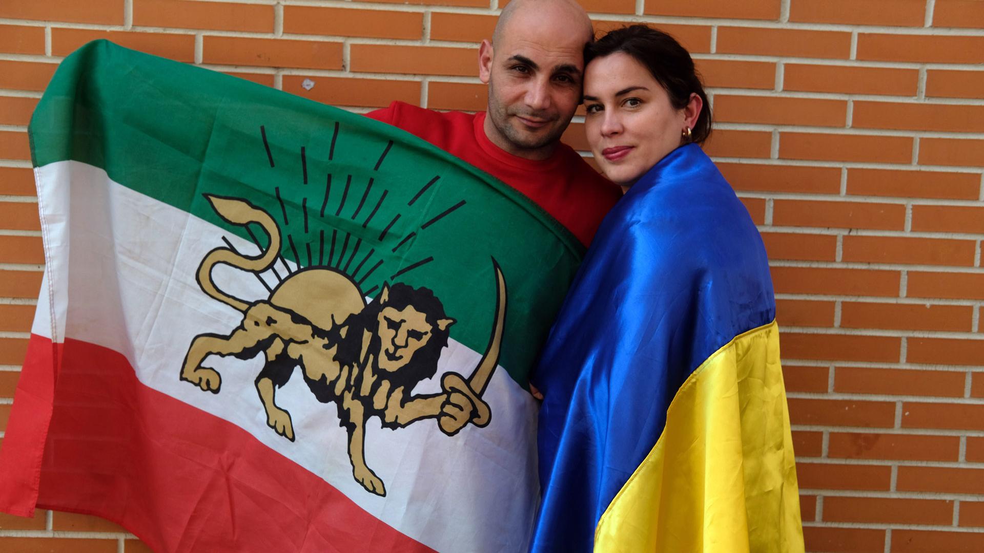 Elena y Sami, con las banderas de sus países, Ucraniana e Irán, en el barrio pamplonés de la Rochapea