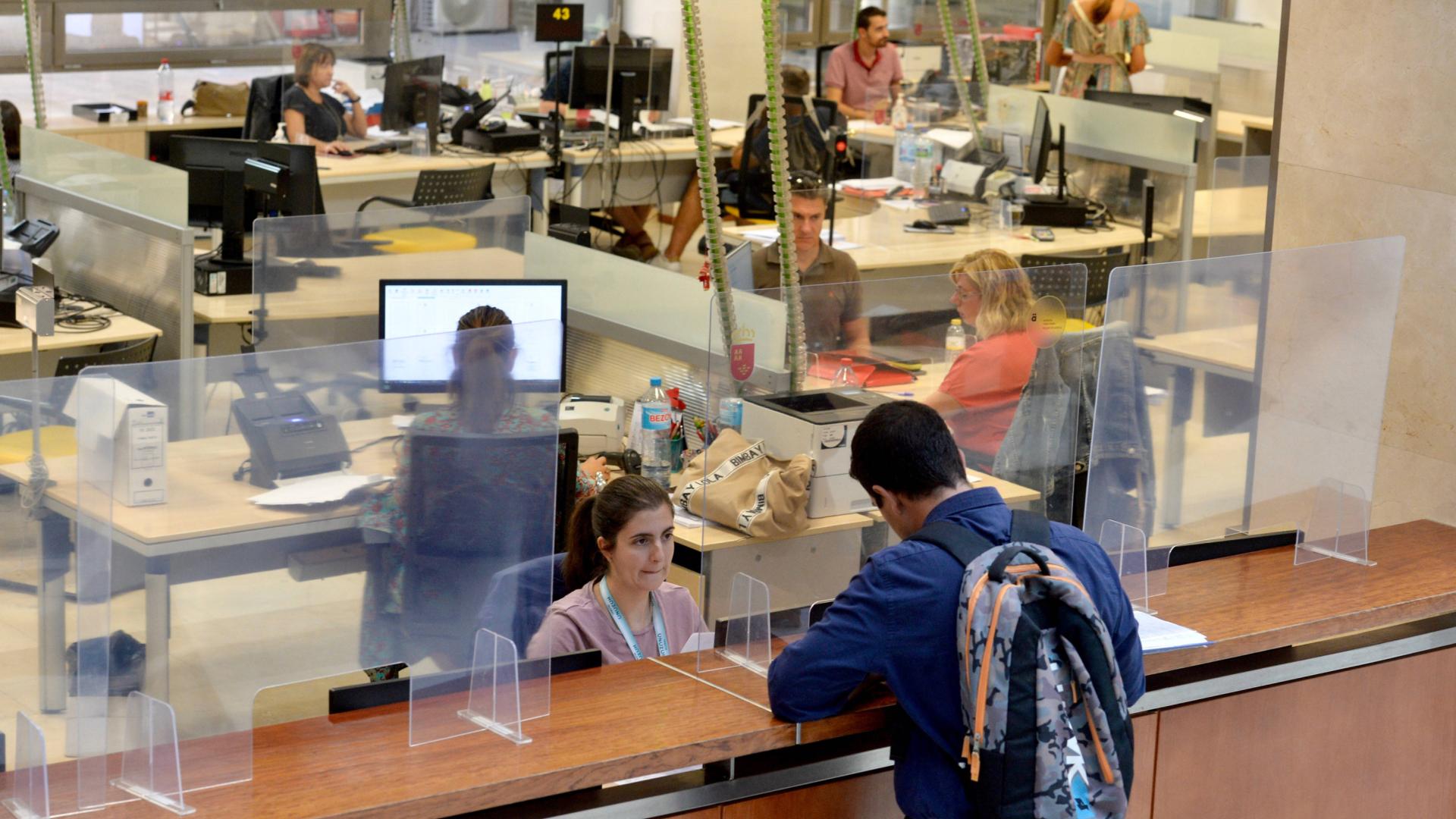 Empleados públicos atendiendo a los usuarios en una oficina de la Administración.