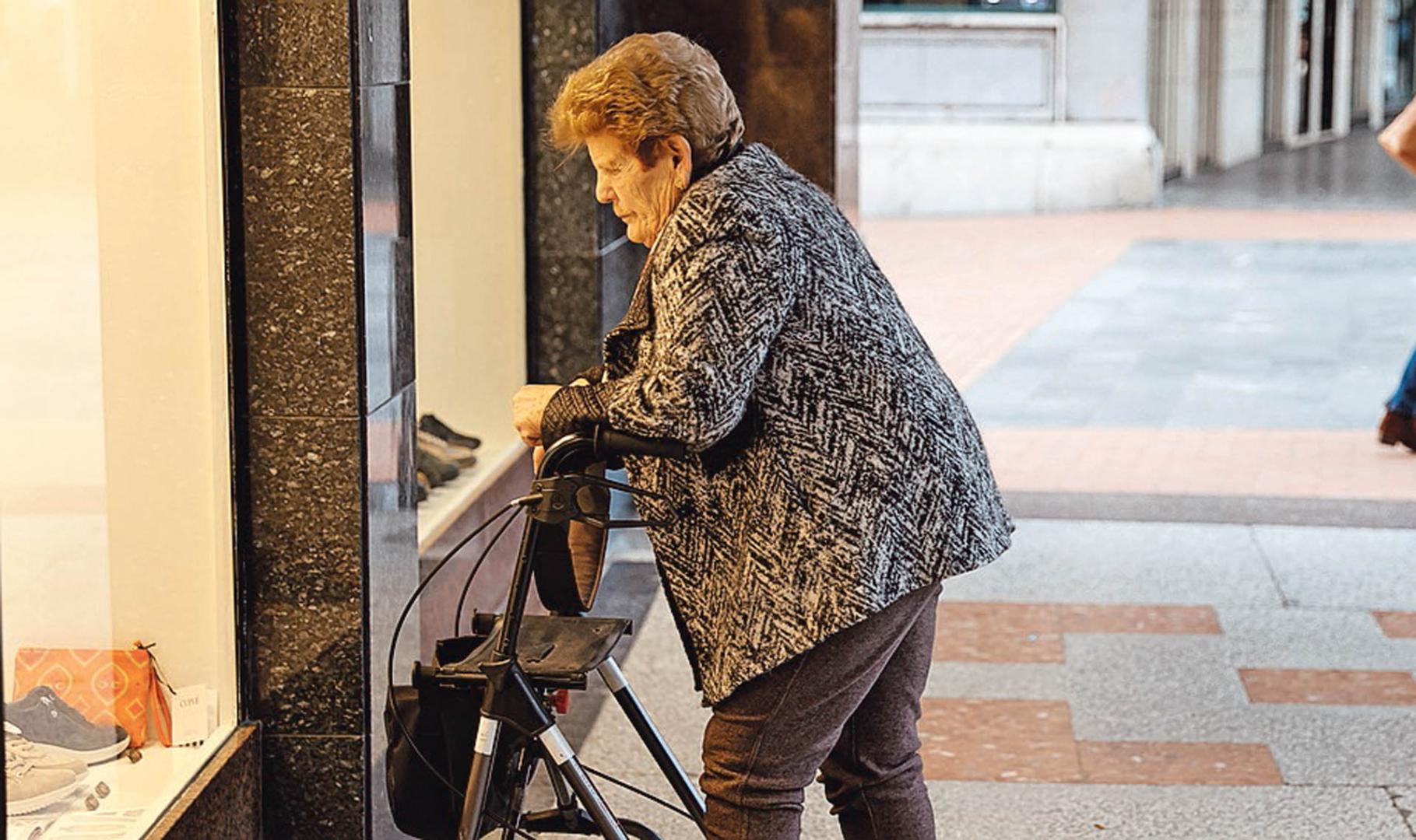 Una pensionista observa un escaparate en Barakaldo, Vizcaya