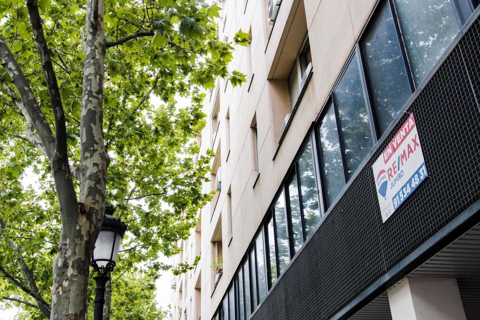 Un cartel de 'En venta' de una inmobiliaria, en un portal del distrito de Embajadores de Madrid