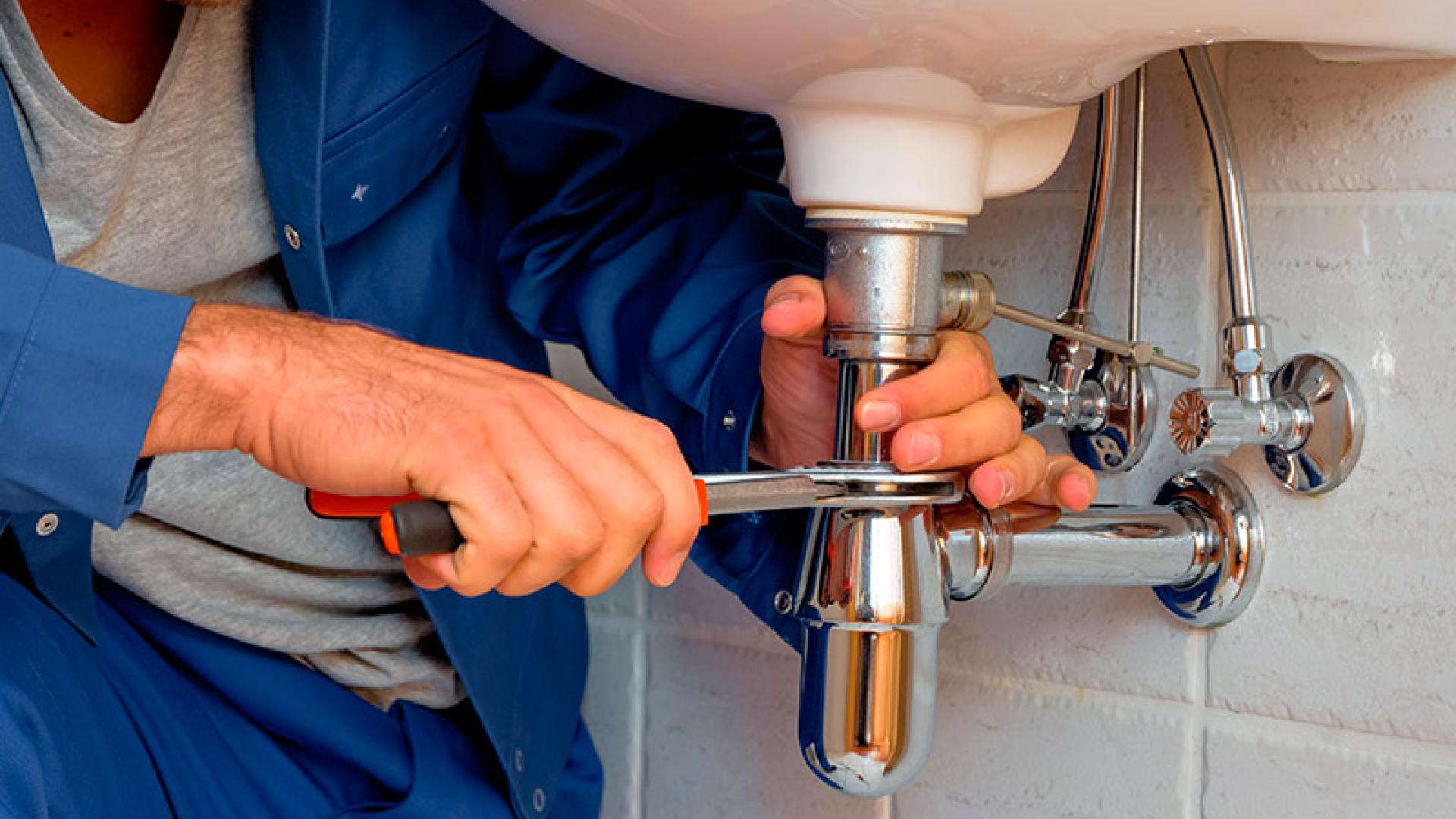 Un fontanero realiza una reparación en un lavabo
