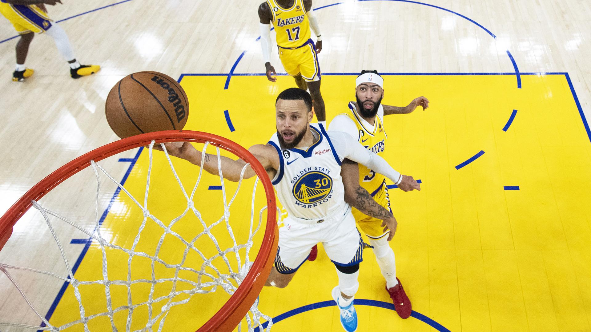 Stephen Curry entra a canasta tras sortear a Anthony Davis durante el encuentro