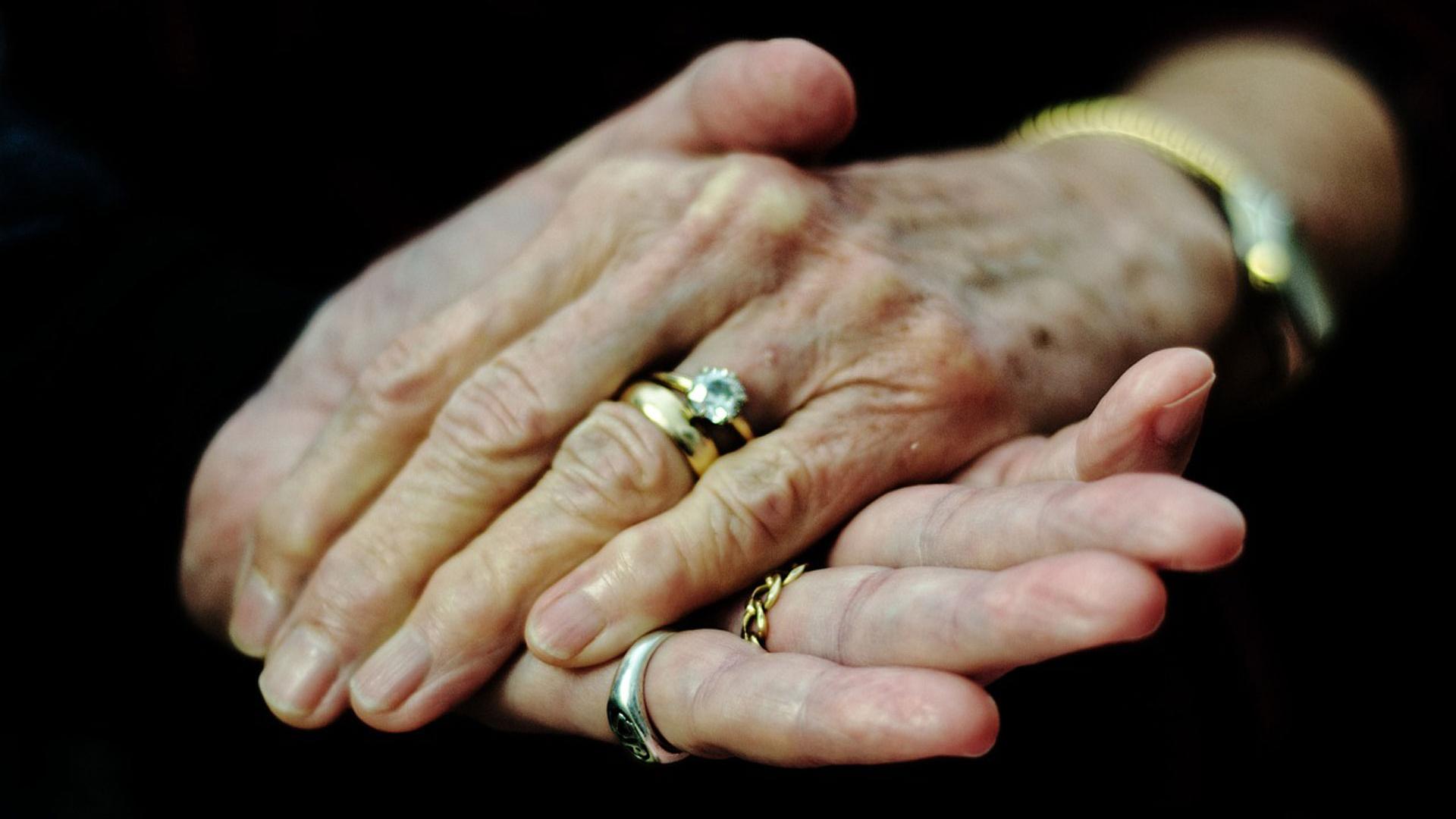 Una pareja de ancianos se agarran la mano