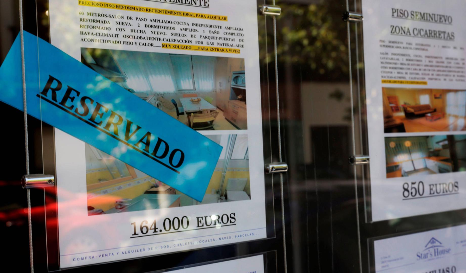 Anuncios de pisos y casas en venta y alquiler en el escaparate de una inmobiliaria, en Madrid