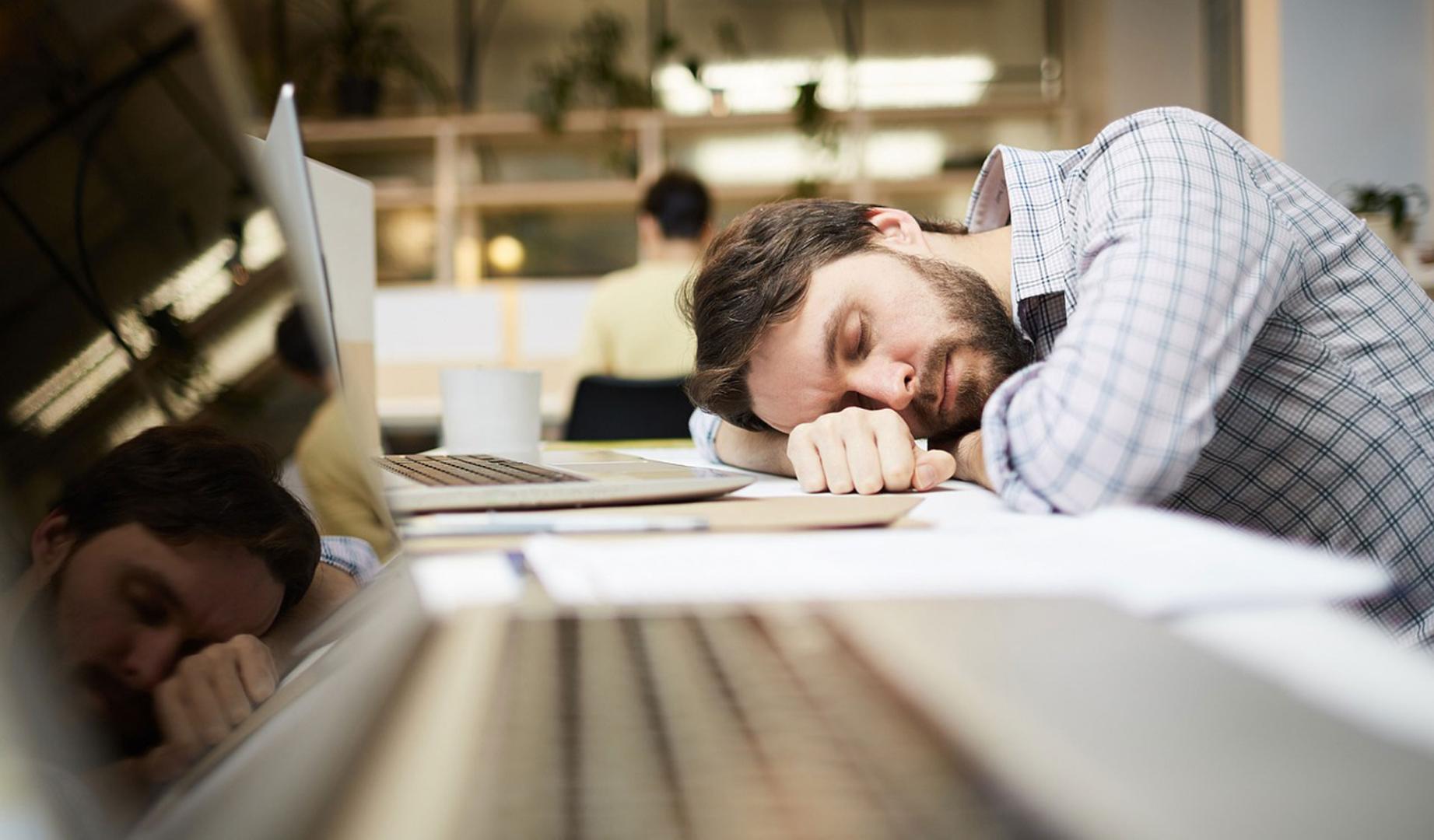 Un hombre dormido en el trabajo después de una noche de insomnio
