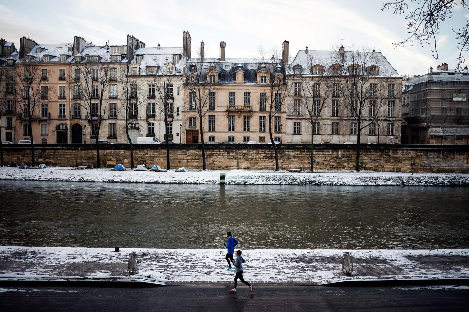 Dos personas hacen running junto al río Sena este jueves en París