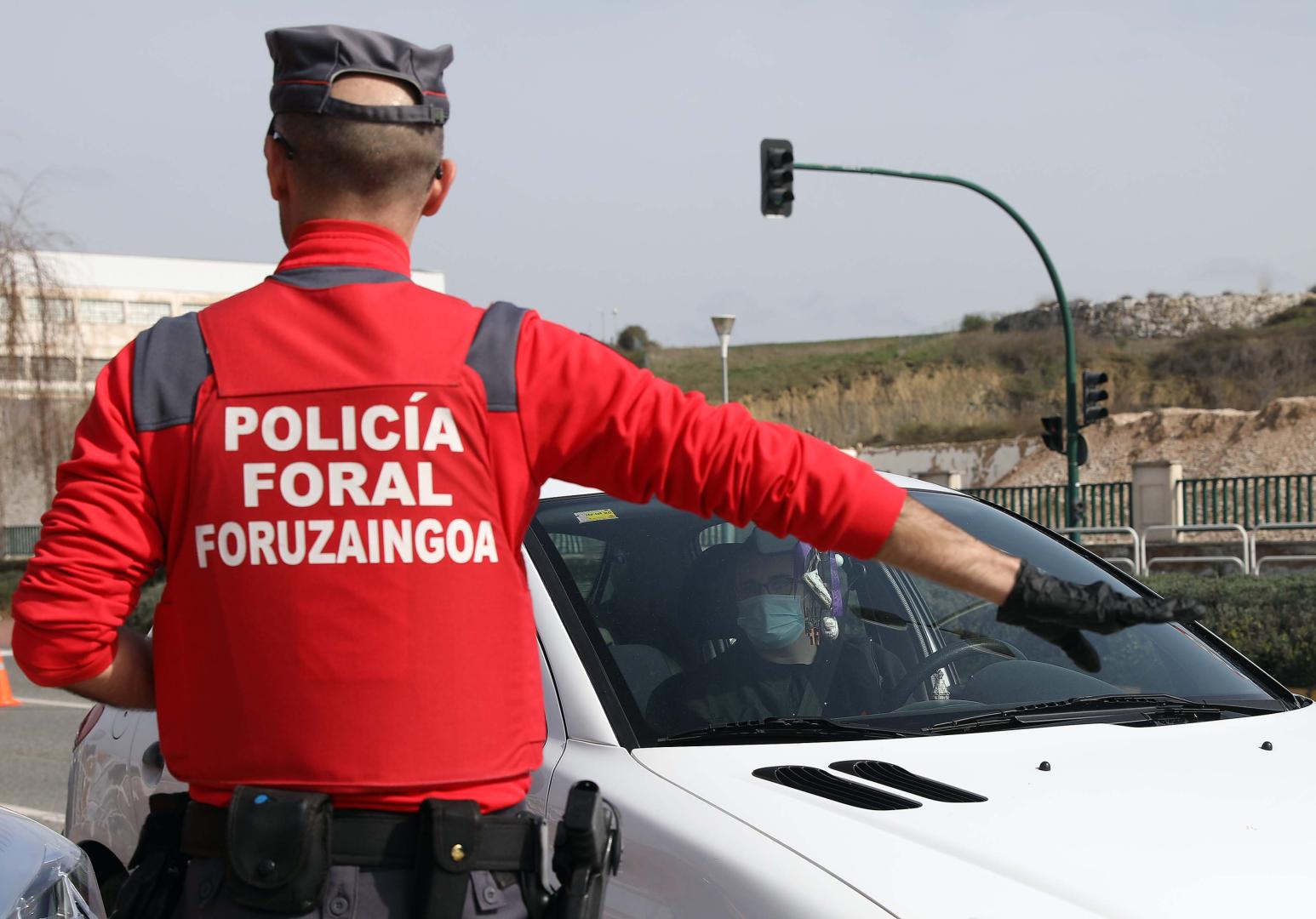 Un agente de Policía Foral pide a una persona que detenga su vehículo en un control, durante la pandemia