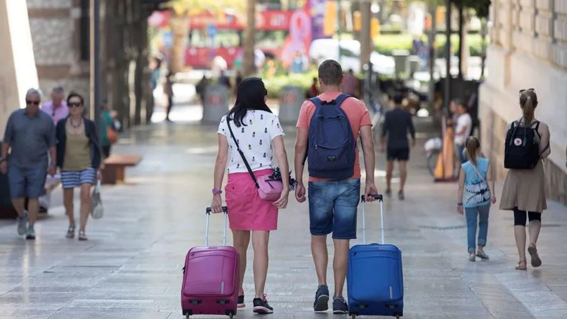 Varios turistas con sus equipajes caminan por el centro de Málaga, en una imagen de archivo
