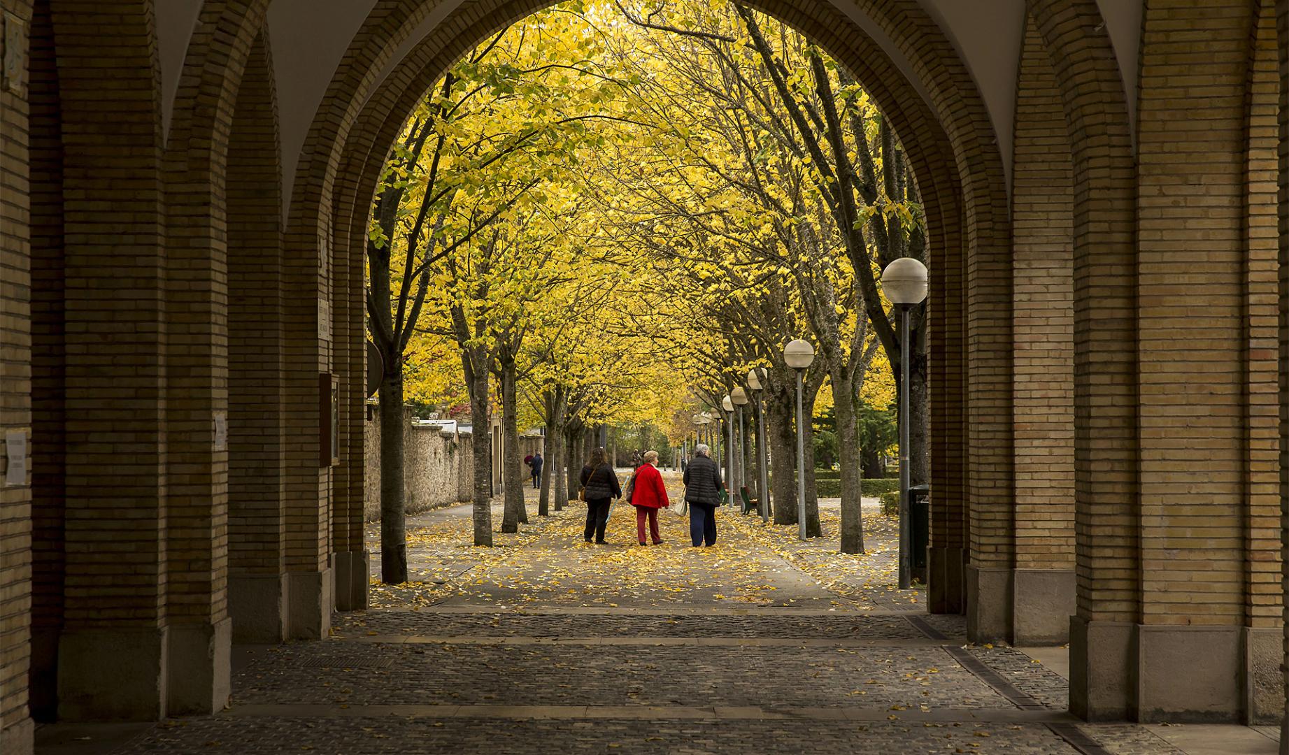 Tres personas pasean por el exterior del cementerio de San José