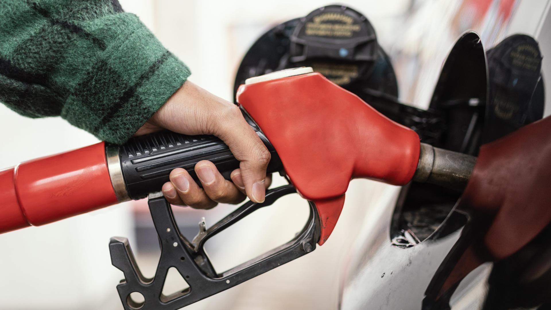 Hombre en la gasolinera con el coche de cerca