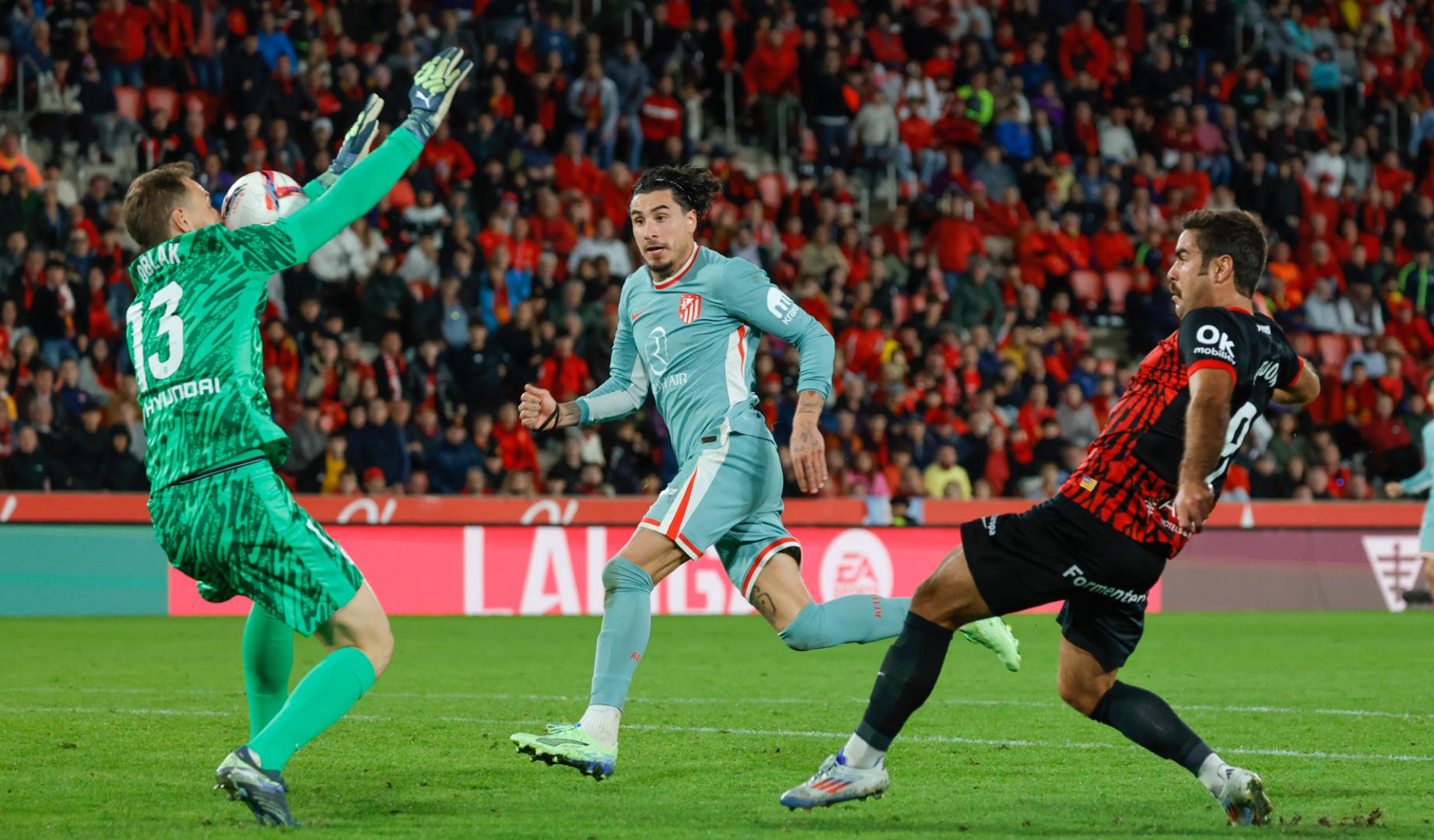 El delantero del Mallorca Abdón Prats (d) intenta batir al portero esloveno del Atlético de Madrid Jan Oblak durante el partido de LaLiga entre el Real Mallorca y el Atlético de Madrid