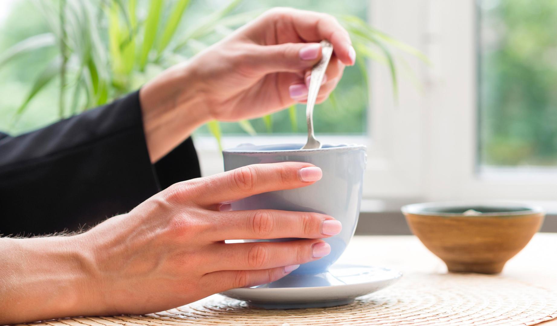 Una mujer, con una taza de infusión