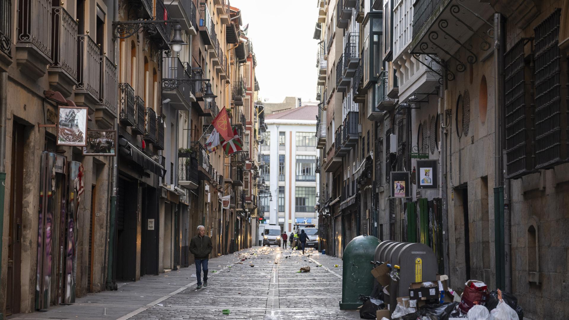 La calle Estafeta, a las 8 de la mañana del domingo, con restos de la fiesta de la noche anterior: botellas, cartones de comida, cristales y copas
