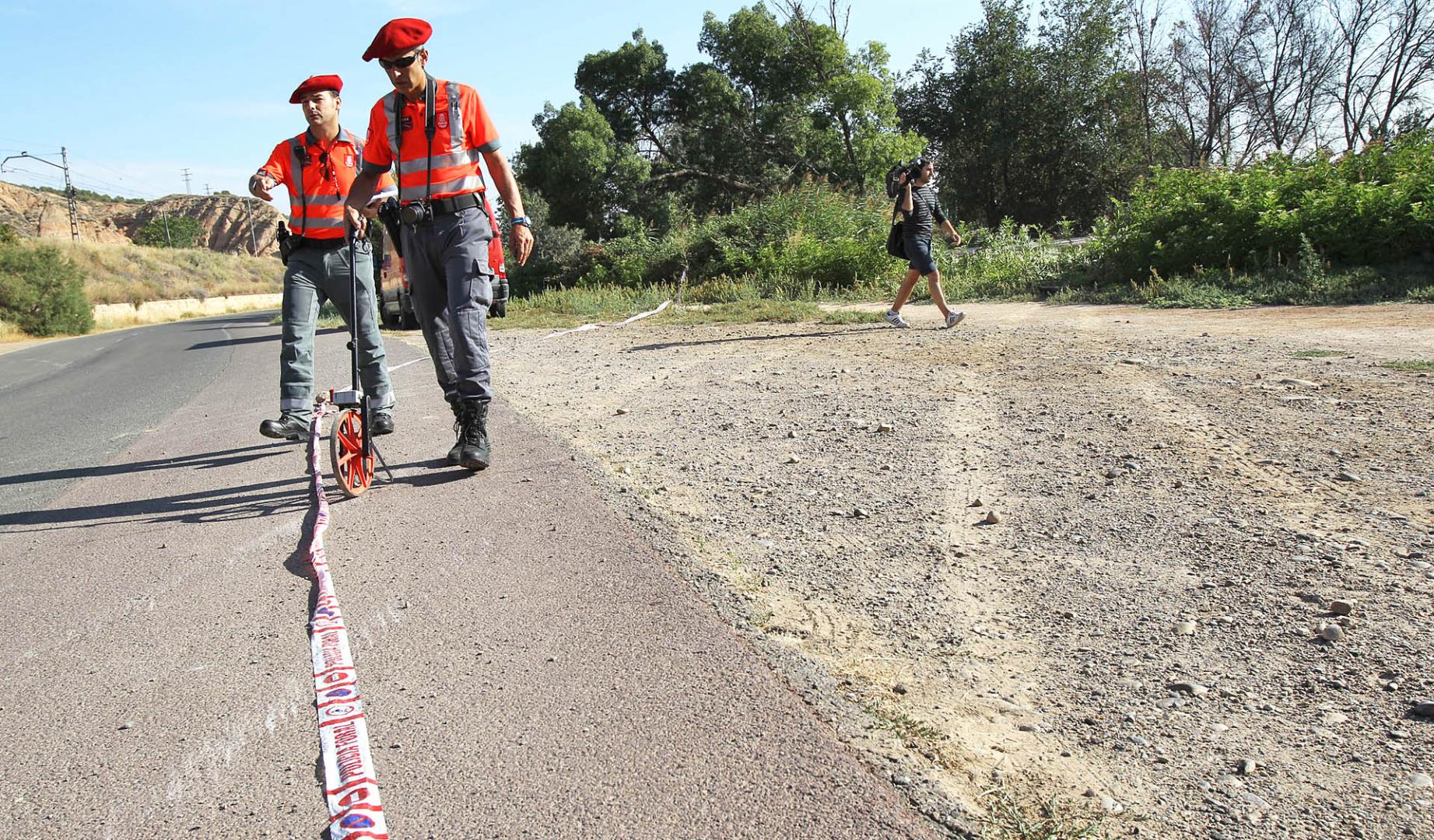 Agentes de la Policía Foral junto a las marcas que dejó el coche al salirse del asfalto, antes de caer a la acequia, en el accidente mortal de La Mejana ocurrido en agosto de 2012 /