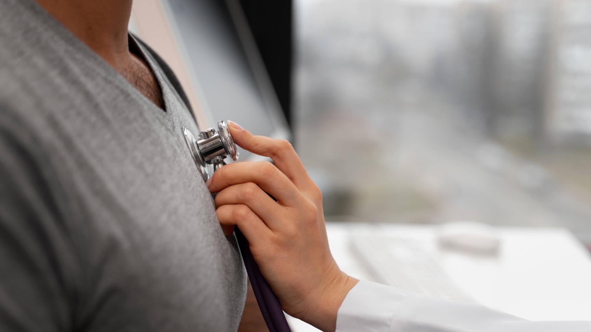 Un médico ausculta a una persona con un fonendo