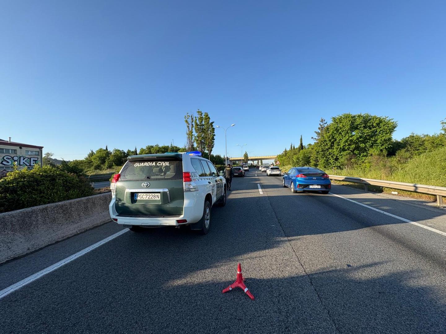 Imagen de un coche de la Guardia Civil, entre las retenciones ocasionadas por al accidente en la Ronda