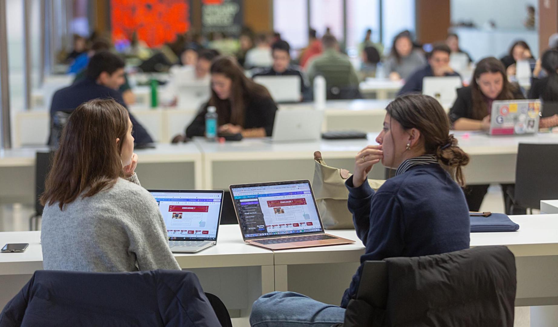 Un par de estudiantes frente al ordenador, en el edificio Amigos de la Universidad de Navarra