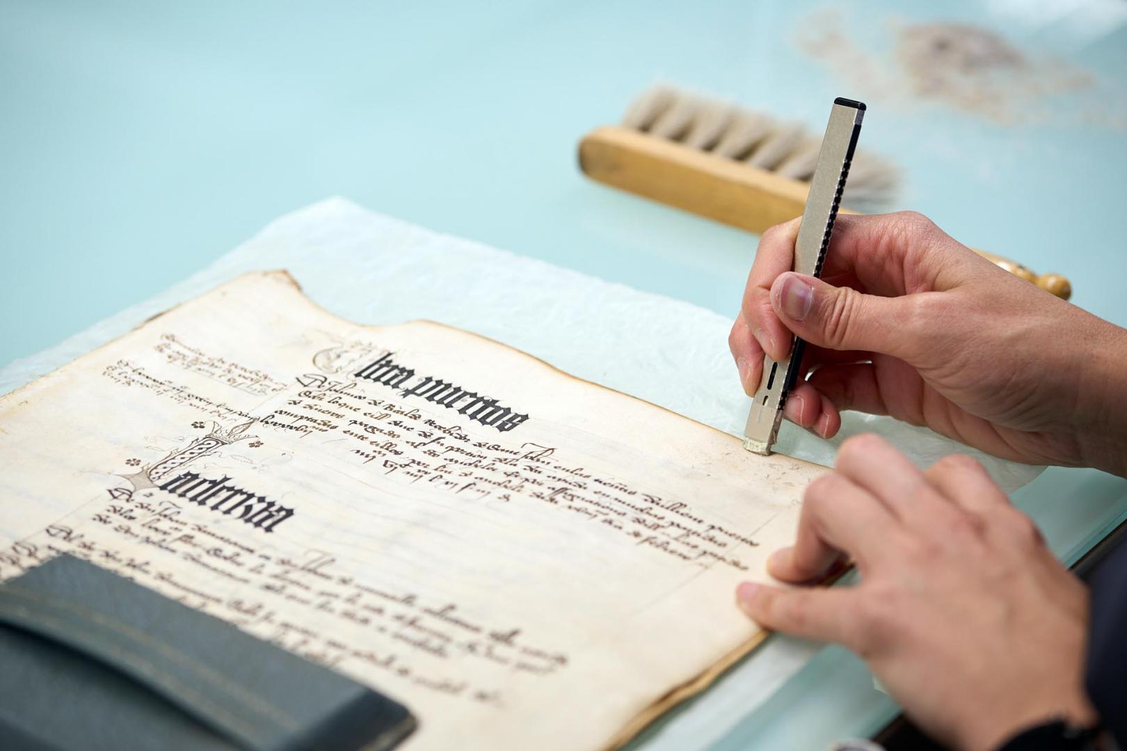 Fotos de la visita guiada al taller de restauración de documentos medievales en el Archivo de Navarra.