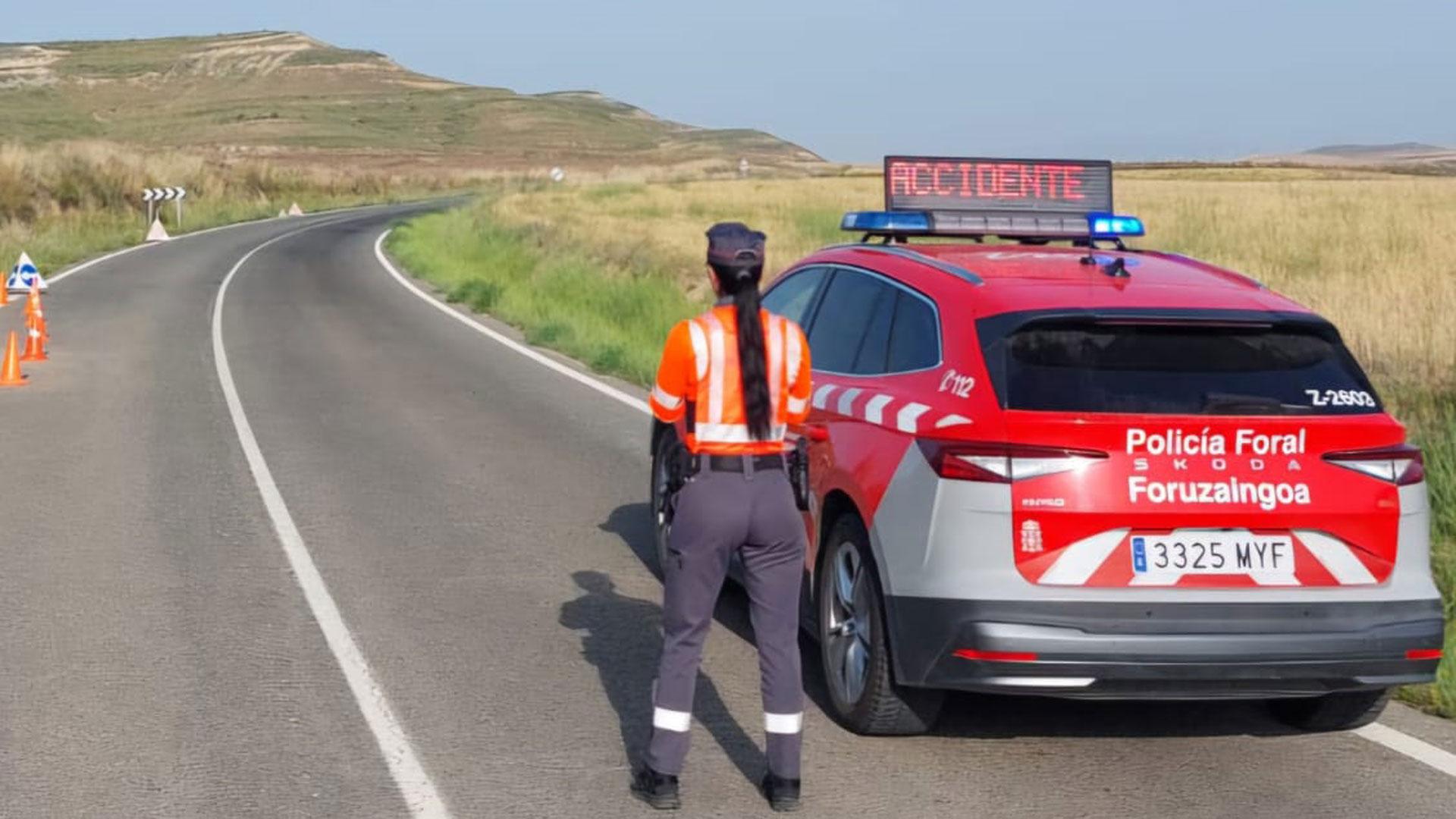 Una policía foral señaliza con su vehículo el lugar de un accidente anterior