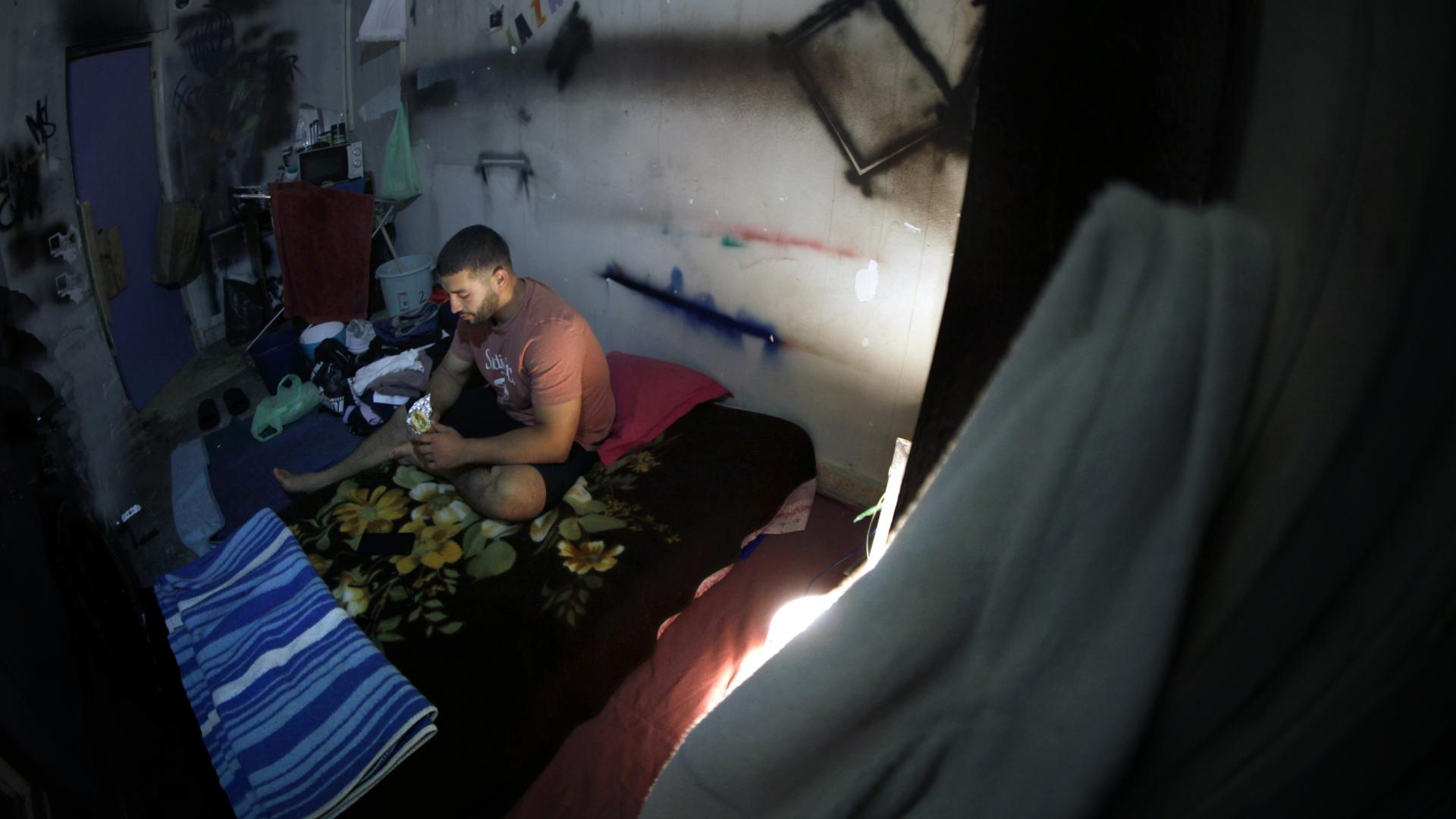 Son las diez de la noche. La habitación donde sobrevive, como todas en el edificio abandonado, está cerrada con cadenas para evitar ocupaciones. Dentro, un colchón sobre el suelo, un espejo roto y un cubo con agua de pozo para asearse. Ishak se sienta y devora en silencio un bocadillo de tortilla con bonito que le ha proporcionado una voluntaria de Apoyo Mutuo. “Es lo primero que como en un día y medio”, dice sin mostrar aflicción.
