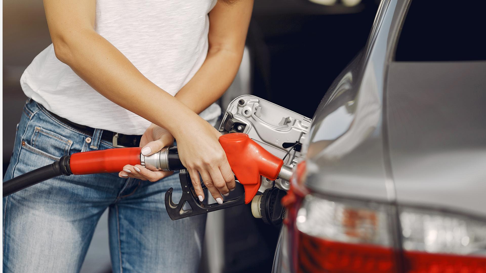 Una mujer, repostando en una gasolinera