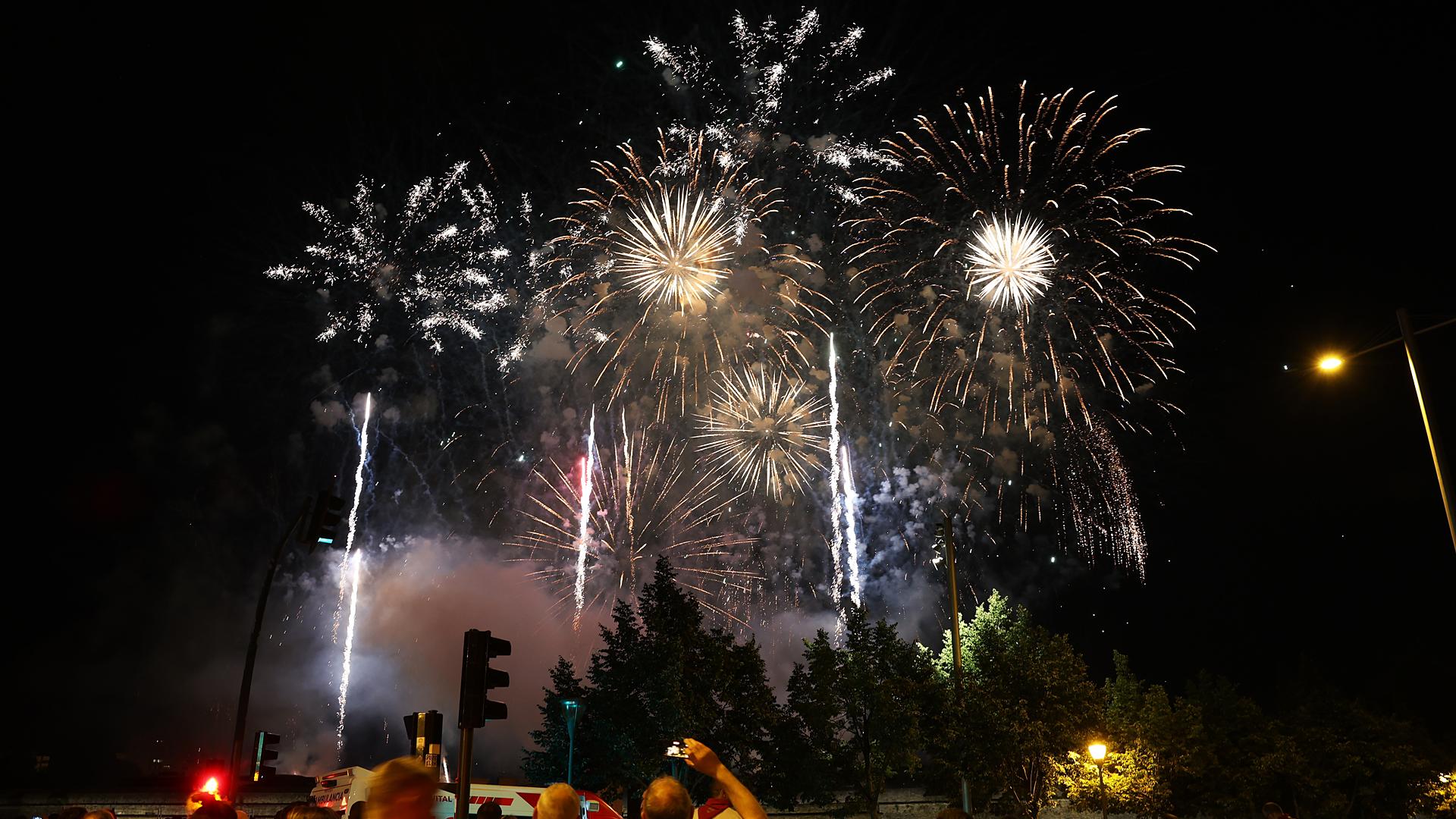 Varias personas observan los fuegos artificiales del 10 de julio /
