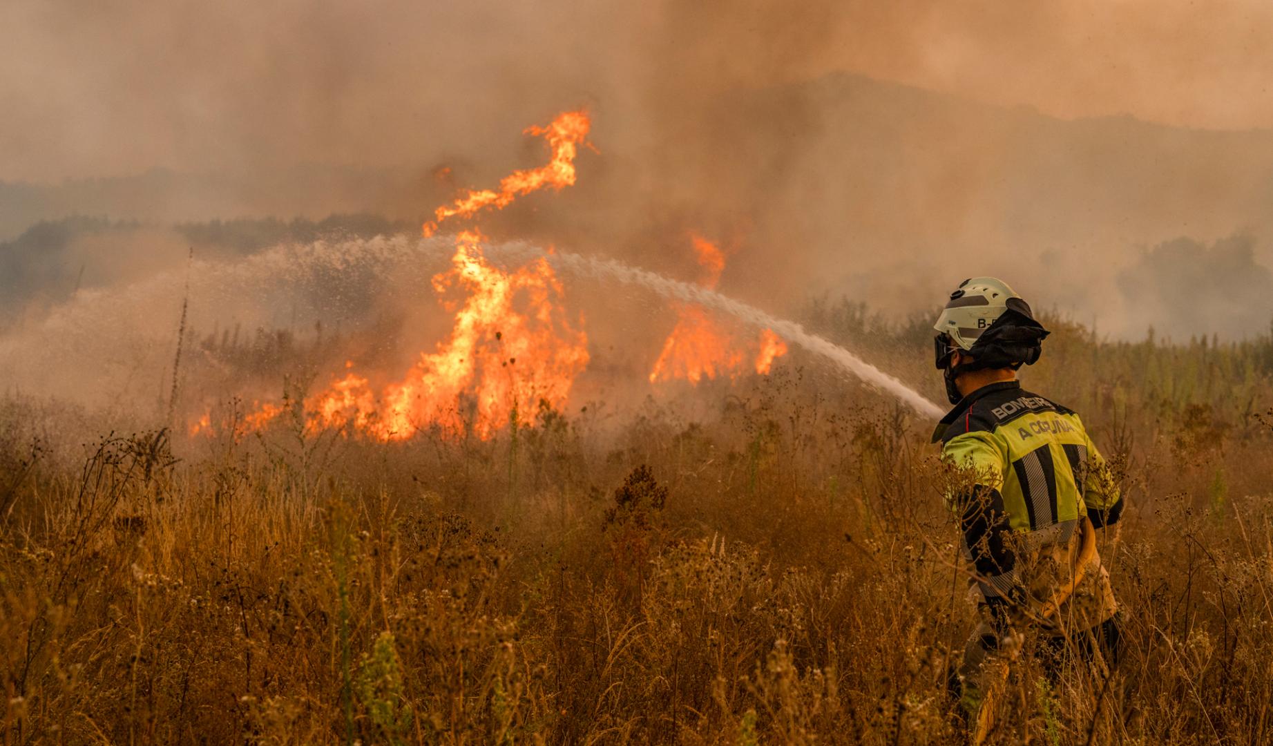 Un bombero trabaja en las labores de extinción del incendio forestal que permanece activo este martes en Monterrei (Ourense)