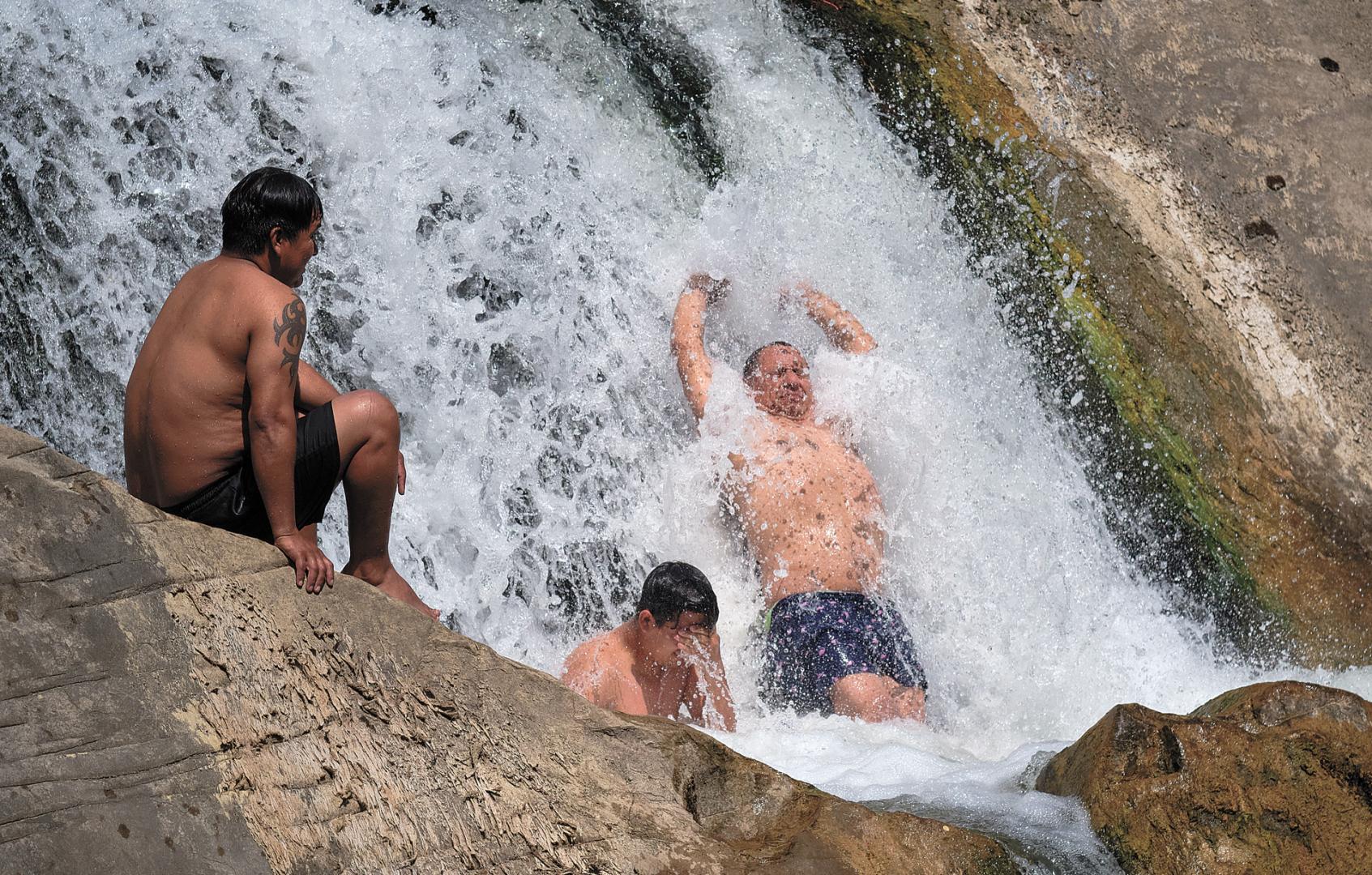 Varias personas se refrescan en la presa de Huarte durante la ola de calor del mes de agosto