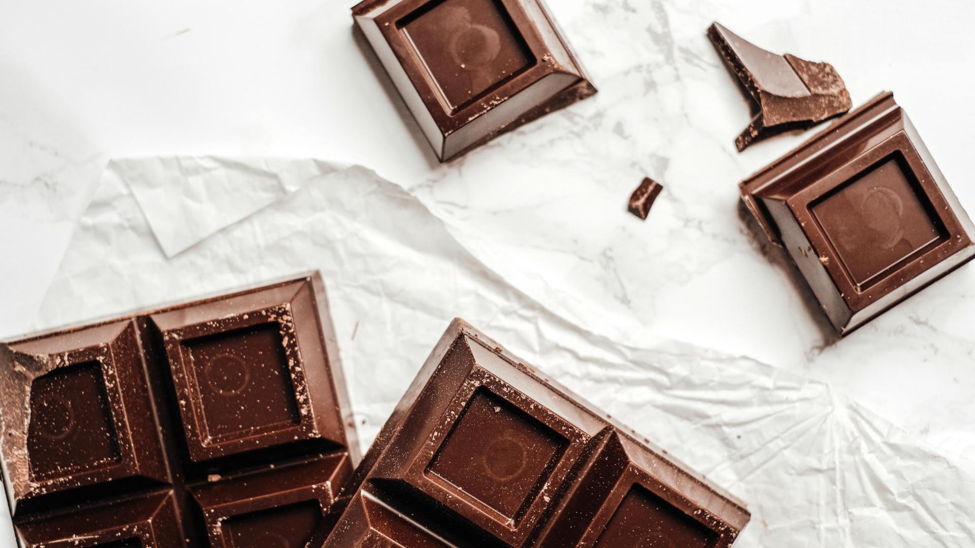 Una tableta de chocolate partido encima de un lienzo blanco