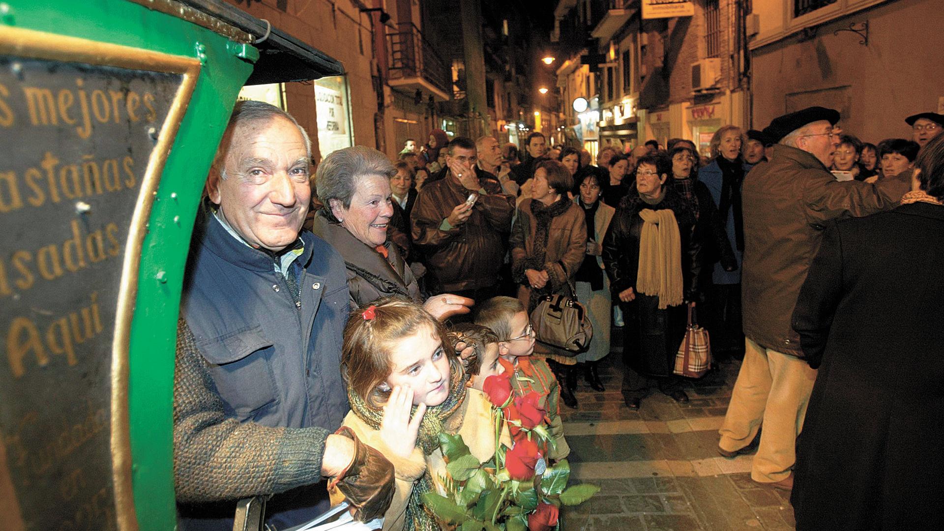 Leyre Martínez de niña con su abuelo Miguel, recordado castañero de la calle Comedias