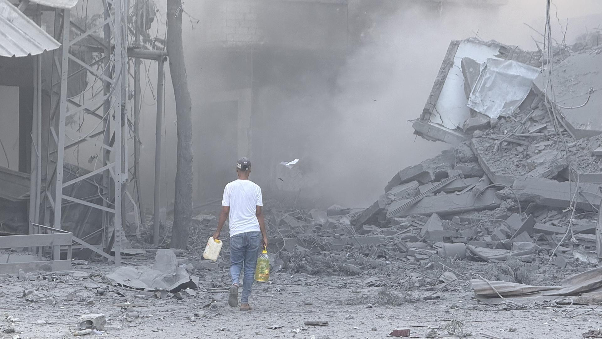 n hombre camina por los escombros tras uno de los ataques lanzados este domingo por Israel en Gaza