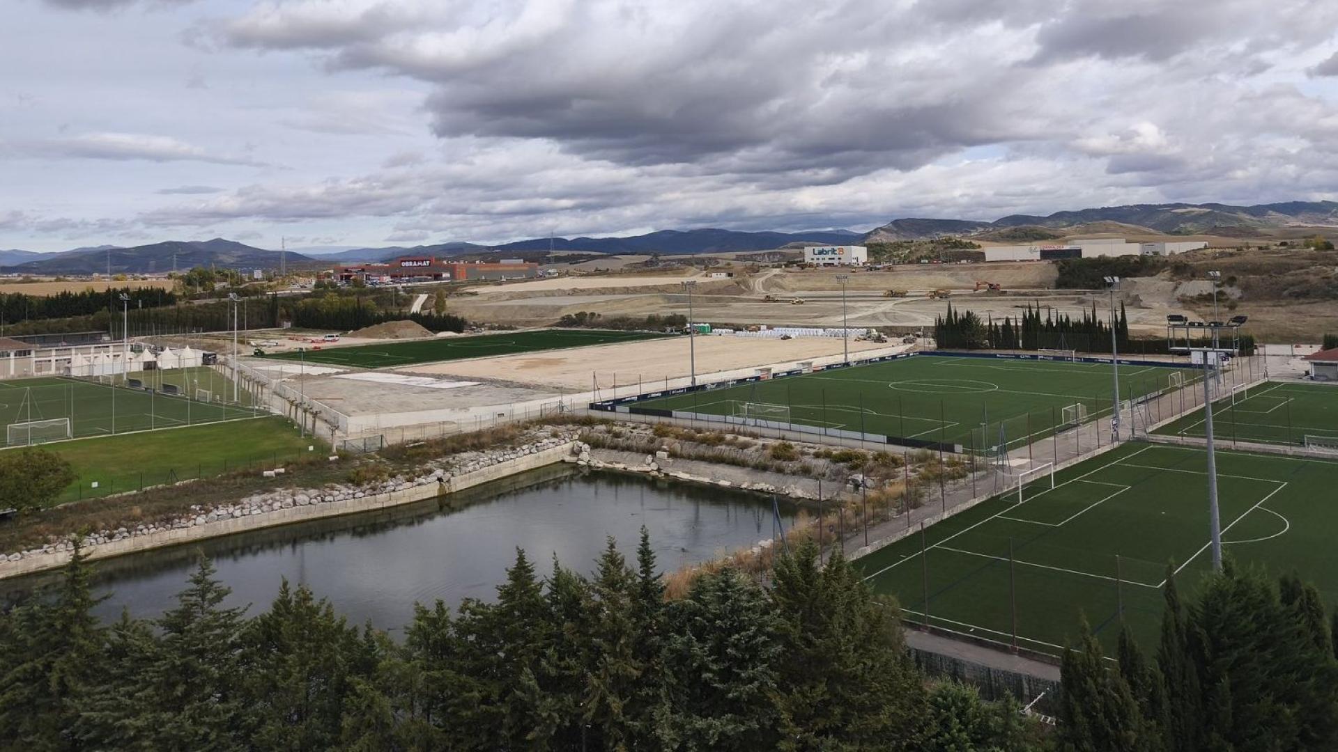 Una vista general de ayer de Tajonar con los terrenos actuales y las obras de la zona nueva al fondo, con los dos primeros campos de hierba artificial (uno se ve casi acabado) y el movimiento de tierras que ha habido para asentar el próximo edificio, los dos campos donde entrenará el primer equipo y el estadio para el Promesas y el Femenino.