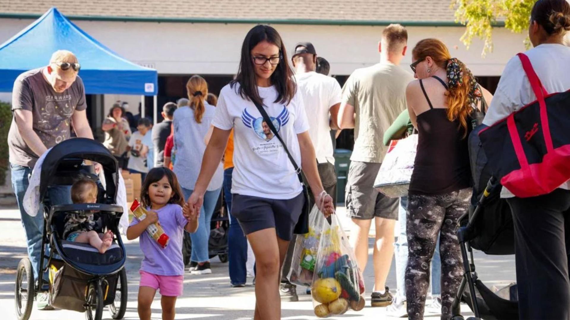 Grupos de familias hacen cola para recibir donativos de alimentos en San Diego, California
