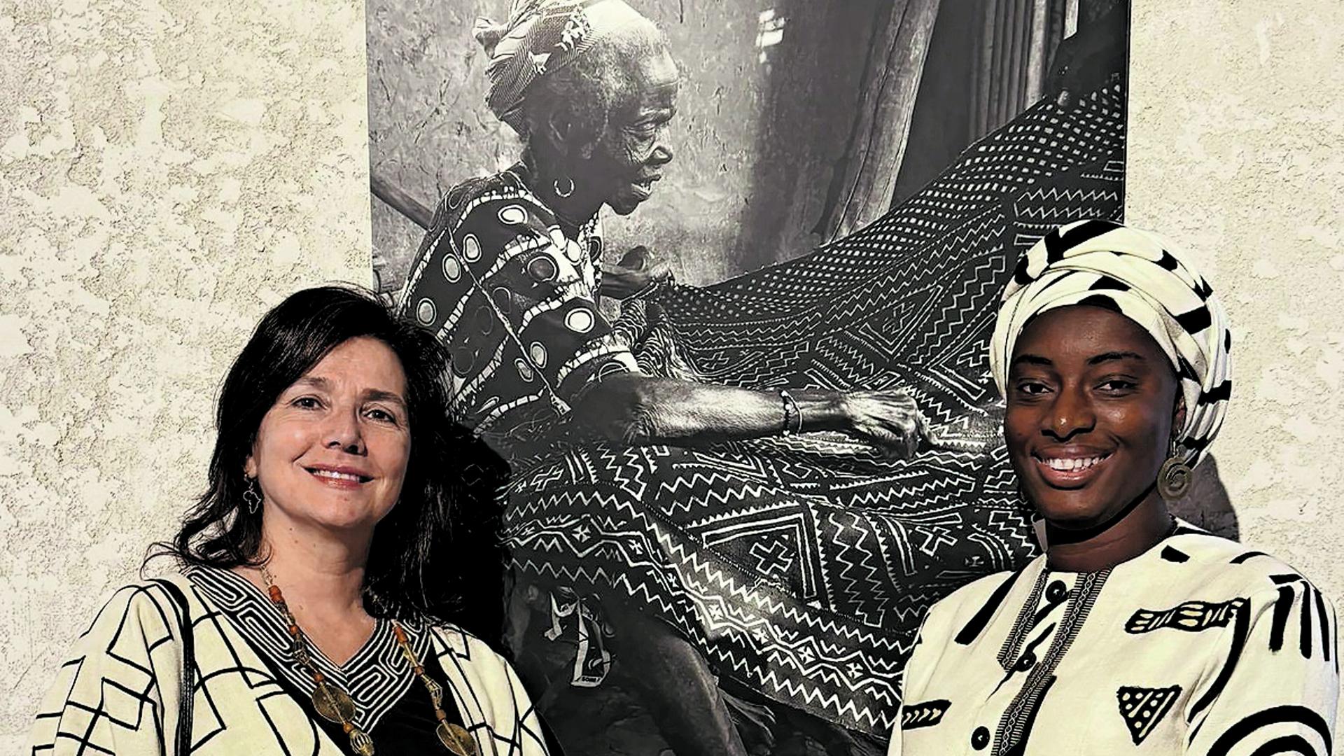 Irene López de Castro y Fatoumata Tioyé Coulibaly, con la foto de  Konimba Diarra, obra de Jonh Damanti
