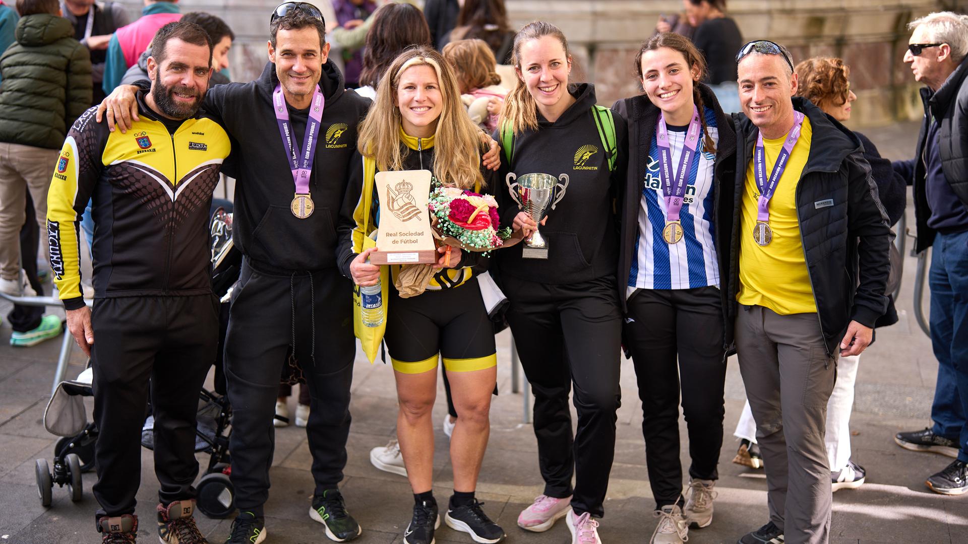 Garazi Ganuza y Leyre Merino, en el centro con sus trofeos, junto a algunos de los patinadores de Lagunak