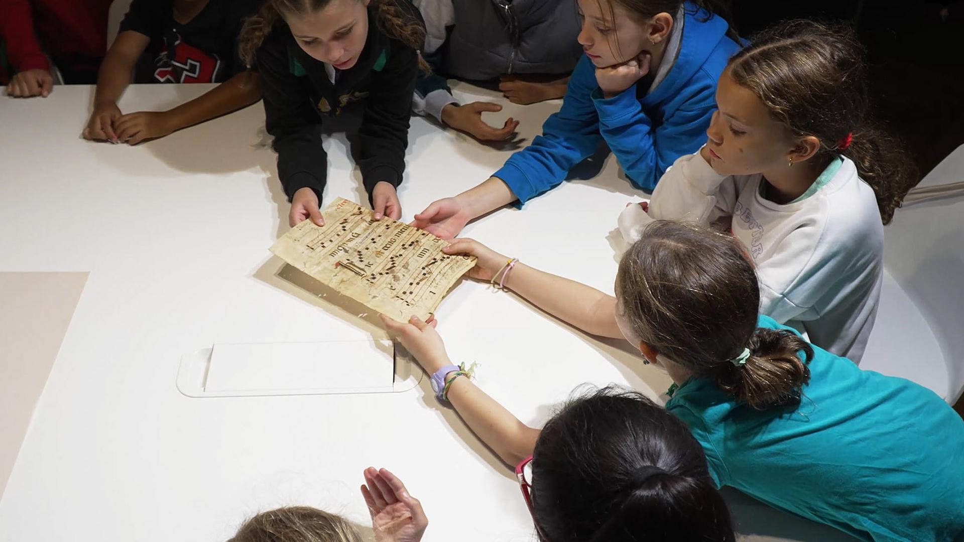 Varios alumnos examina una partitura durante una de las visitas al Archivo Municipal de Pamplona /