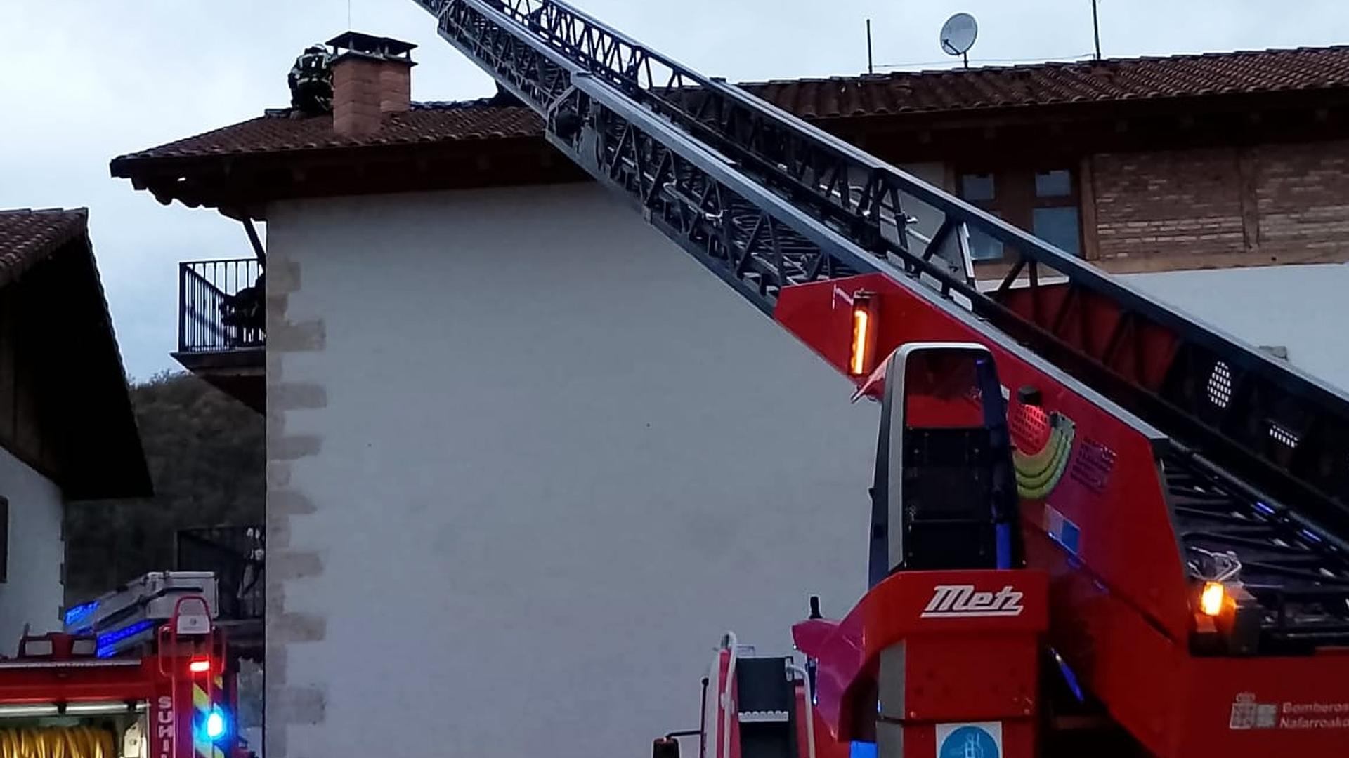 Bomberos de Navarra trabajan en la cubierta de la vivienda afectada por las llamas /