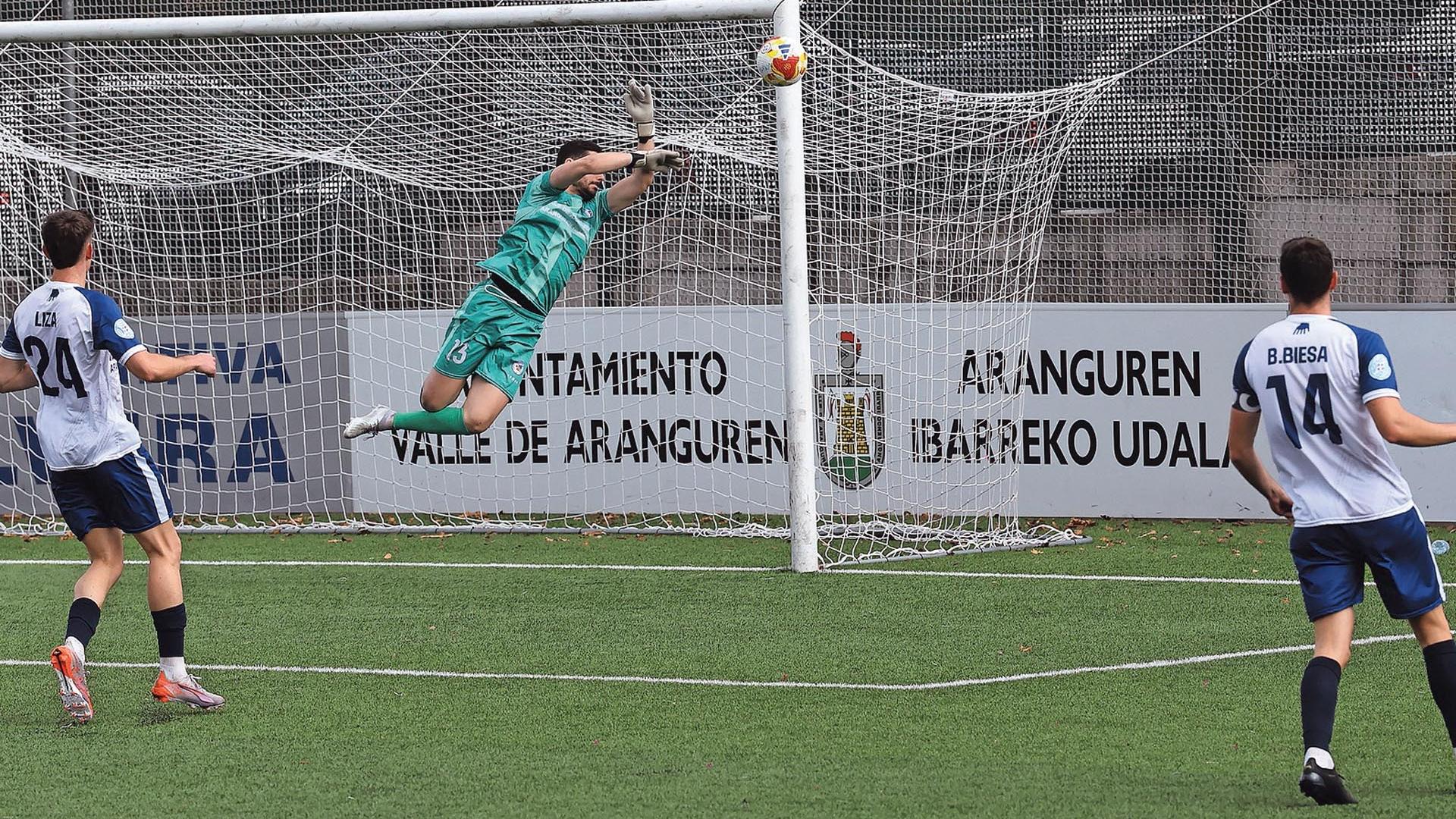 Ángel Fraga, guardameta de la Mutilvera, se eleva en el  aire para desviar un disparo del Deportivo Aragón ante Liza y Biesa