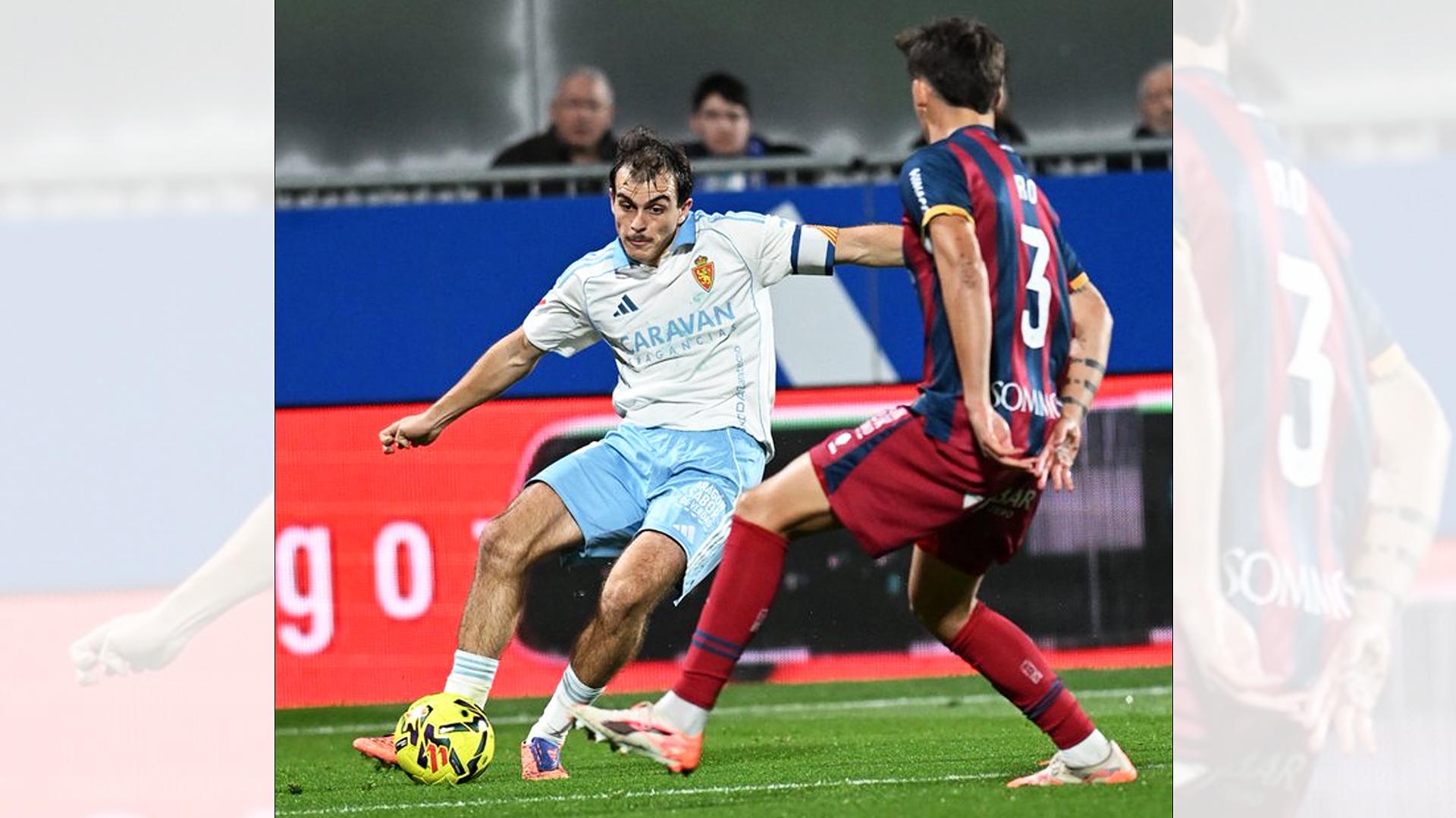El capitán del Zaragoza "Francho" Serrano busca el centro ante el defensa del Huesca Abajas /