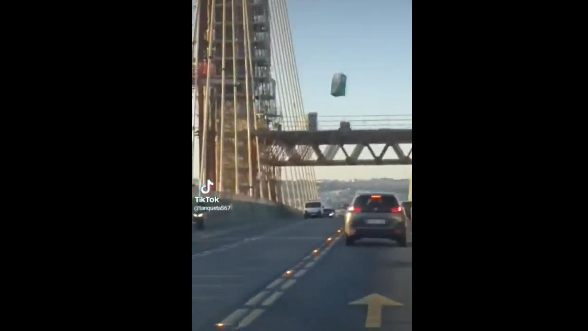Imagen del vídeo, del momento en el que el retrete cae sobre la calzada del puente del Centenario de Sevilla