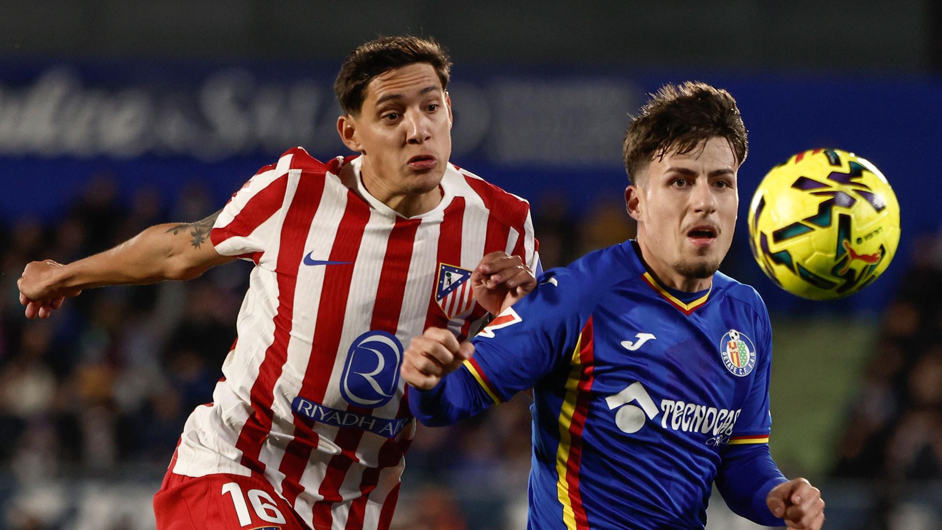 El centrocampista del Getafe Adrián Liso (d) pelea un balón con el defensa argentino del Atlético de Madrid Manuel Molina