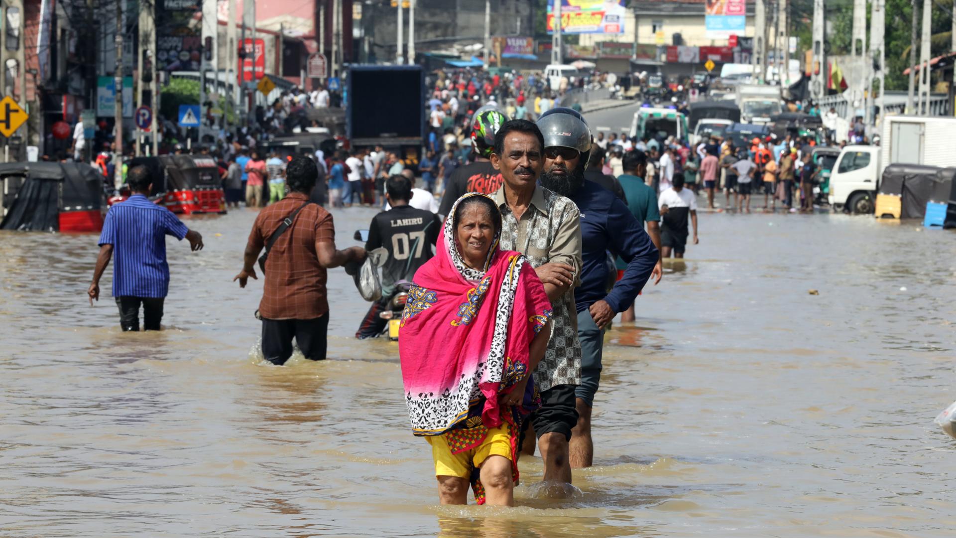 Varias personas caminas por las calles inundadas en Colombo, Sri Lanka