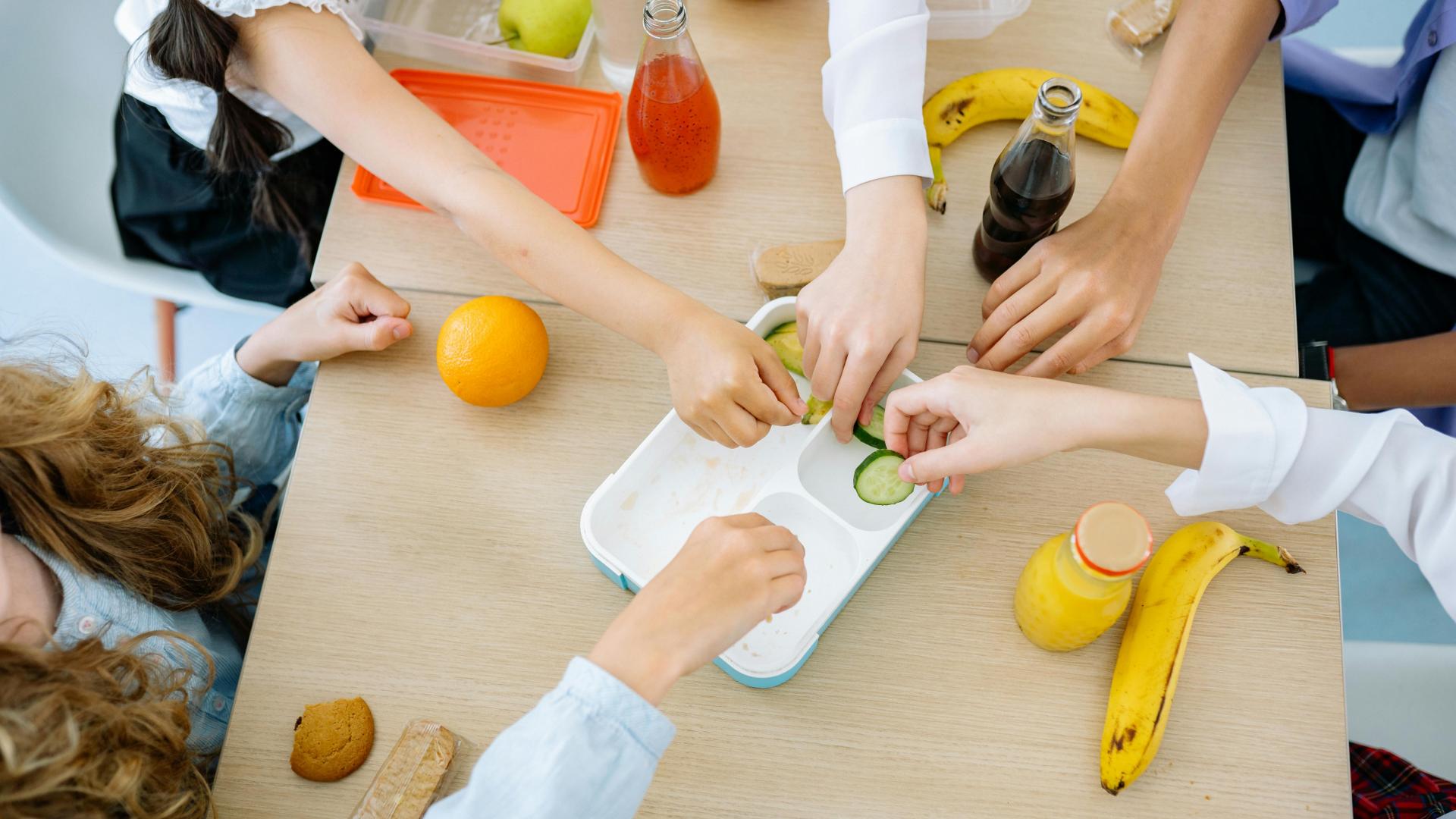 Un grupo de menores acerca sus manos en una mesa del comedor escolar de San Donato, en Etxarri Aranatz.