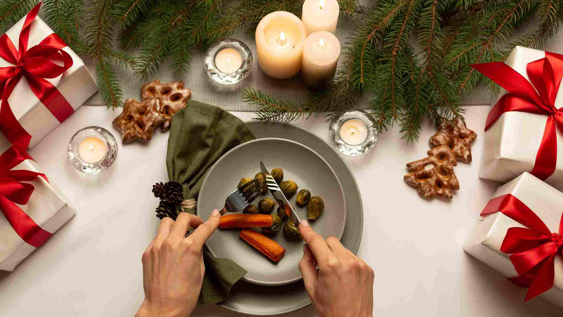 Una mesa de Navidad con un plato de zanahorias y coles de Bruselas